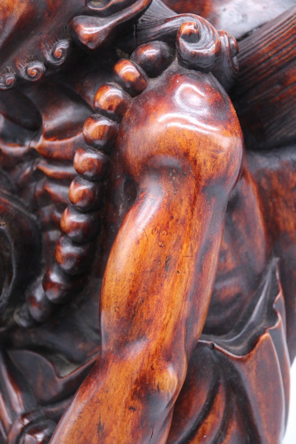 A late 19th-century Japanese Meiji period carved hardwood okimono depicting a standing male figure with a staff, scroll, and fruit on a textured base. View XXVII