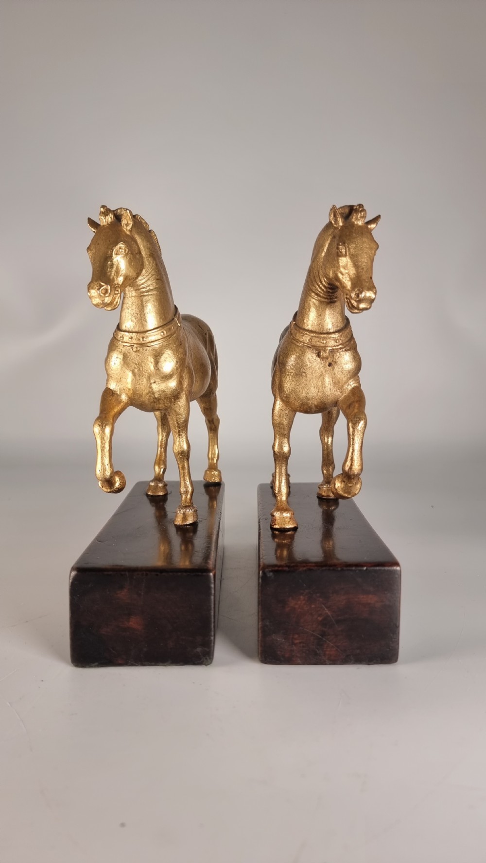 A pair of 19th-century Italian gilt bronze horse sculptures depicted facing each other, mounted on rectangular dark olive wood bases. View III