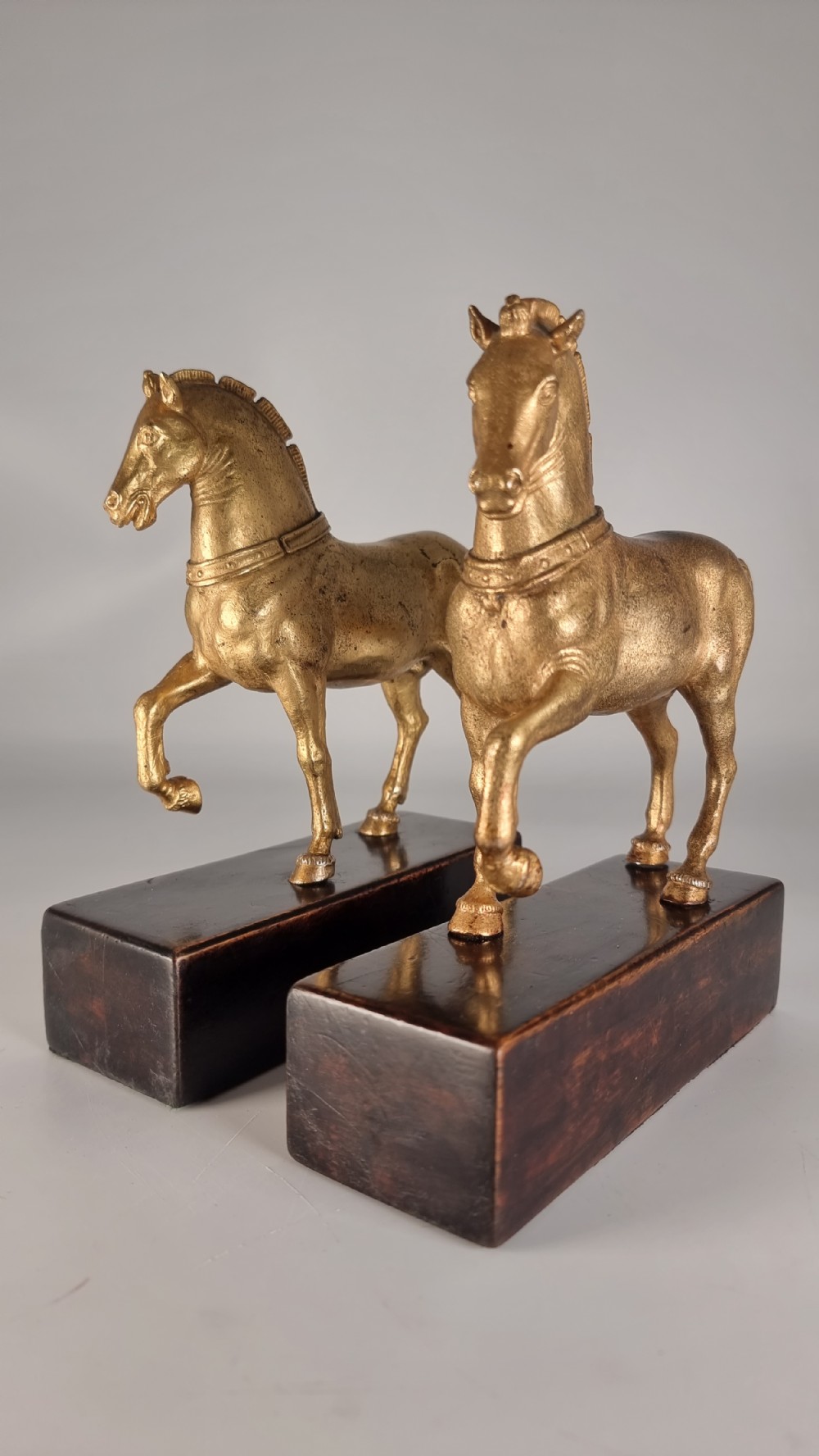 A pair of 19th-century Italian gilt bronze horse sculptures depicted facing each other, mounted on rectangular dark olive wood bases. View IV