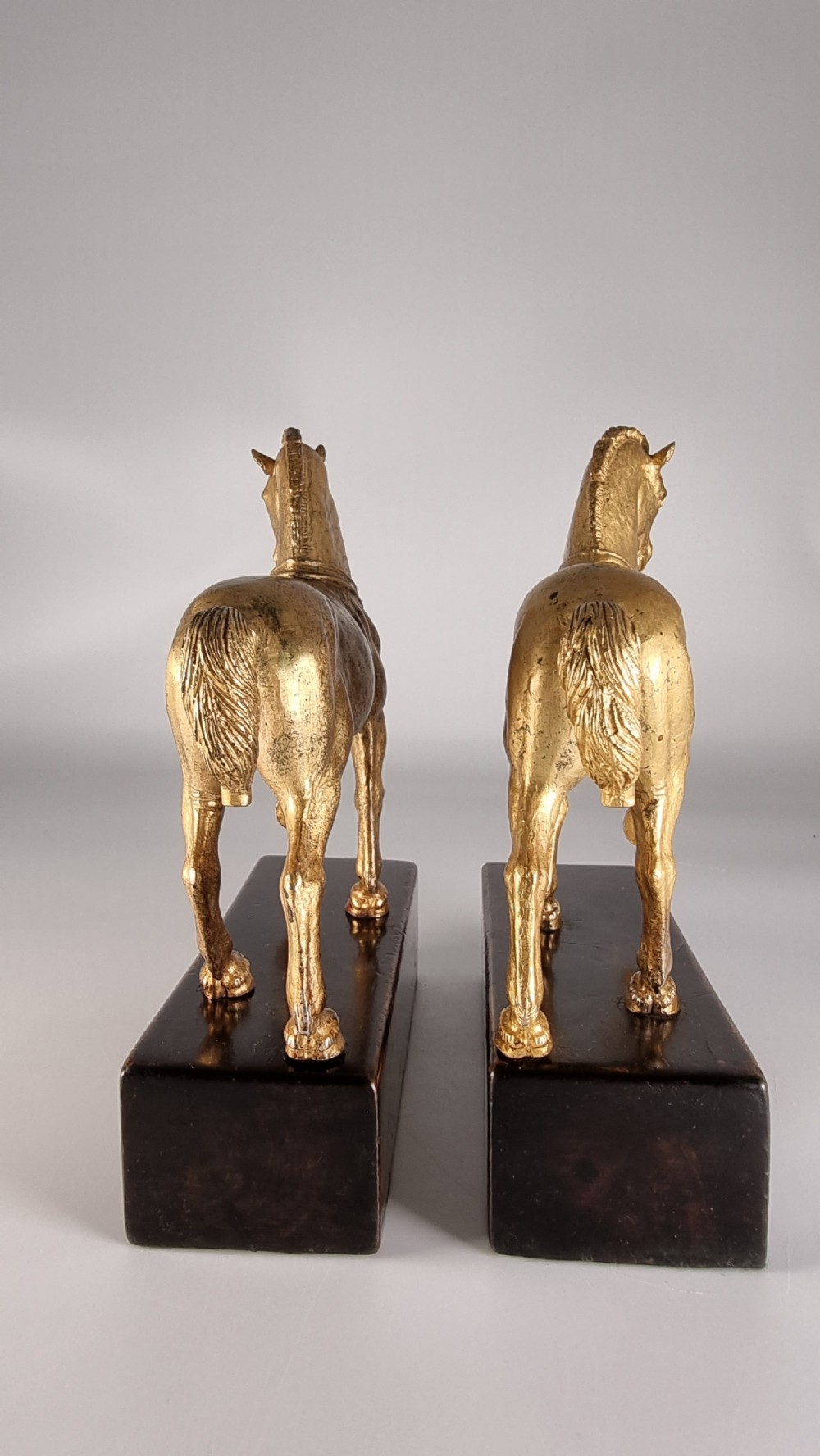 A pair of 19th-century Italian gilt bronze horse sculptures depicted facing each other, mounted on rectangular dark olive wood bases. View VI