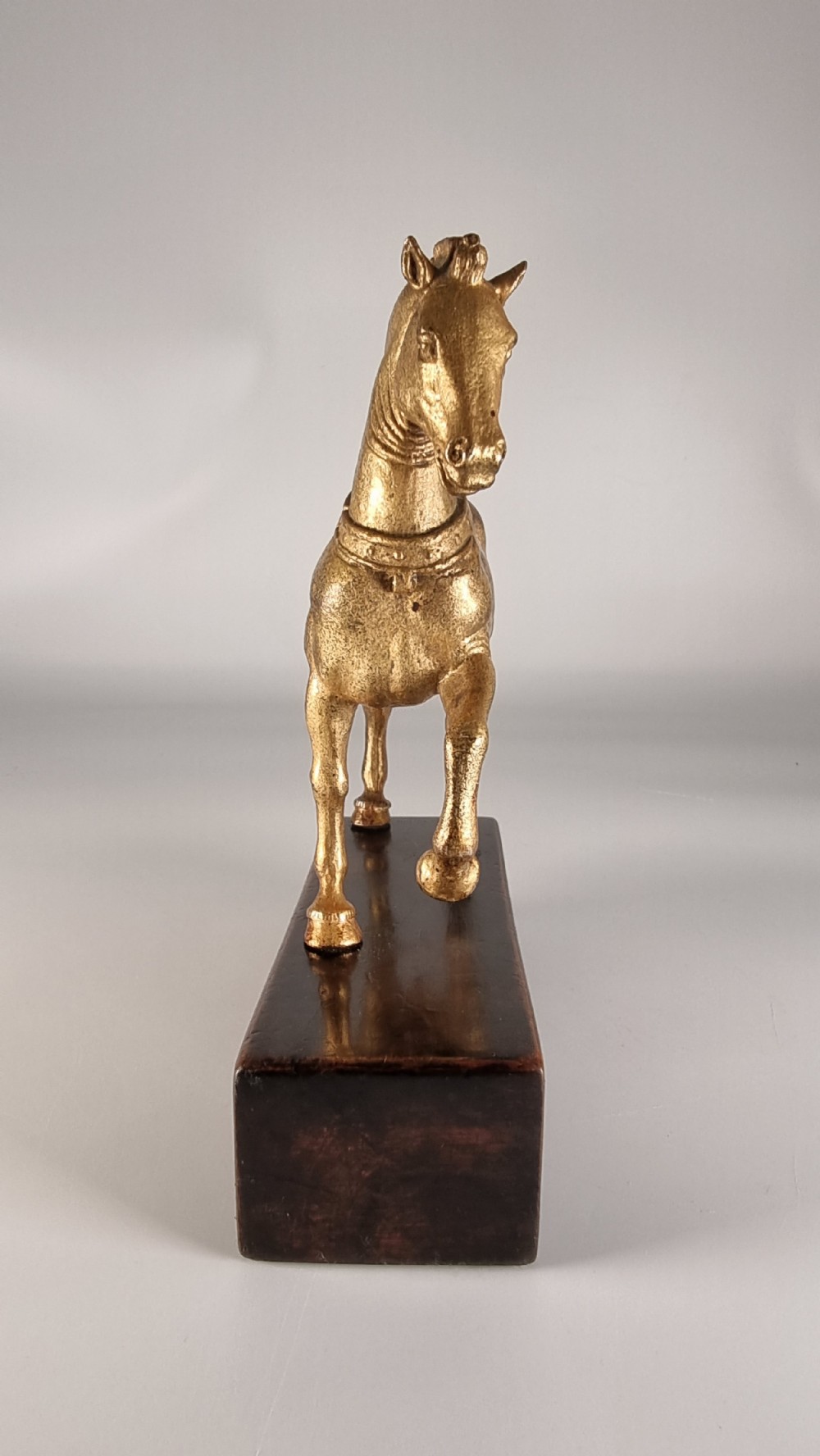 A pair of 19th-century Italian gilt bronze horse sculptures depicted facing each other, mounted on rectangular dark olive wood bases. View IX