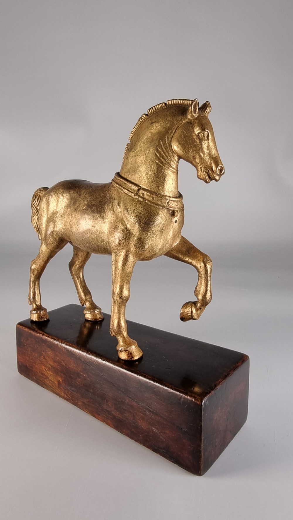 A pair of 19th-century Italian gilt bronze horse sculptures depicted facing each other, mounted on rectangular dark olive wood bases. View X