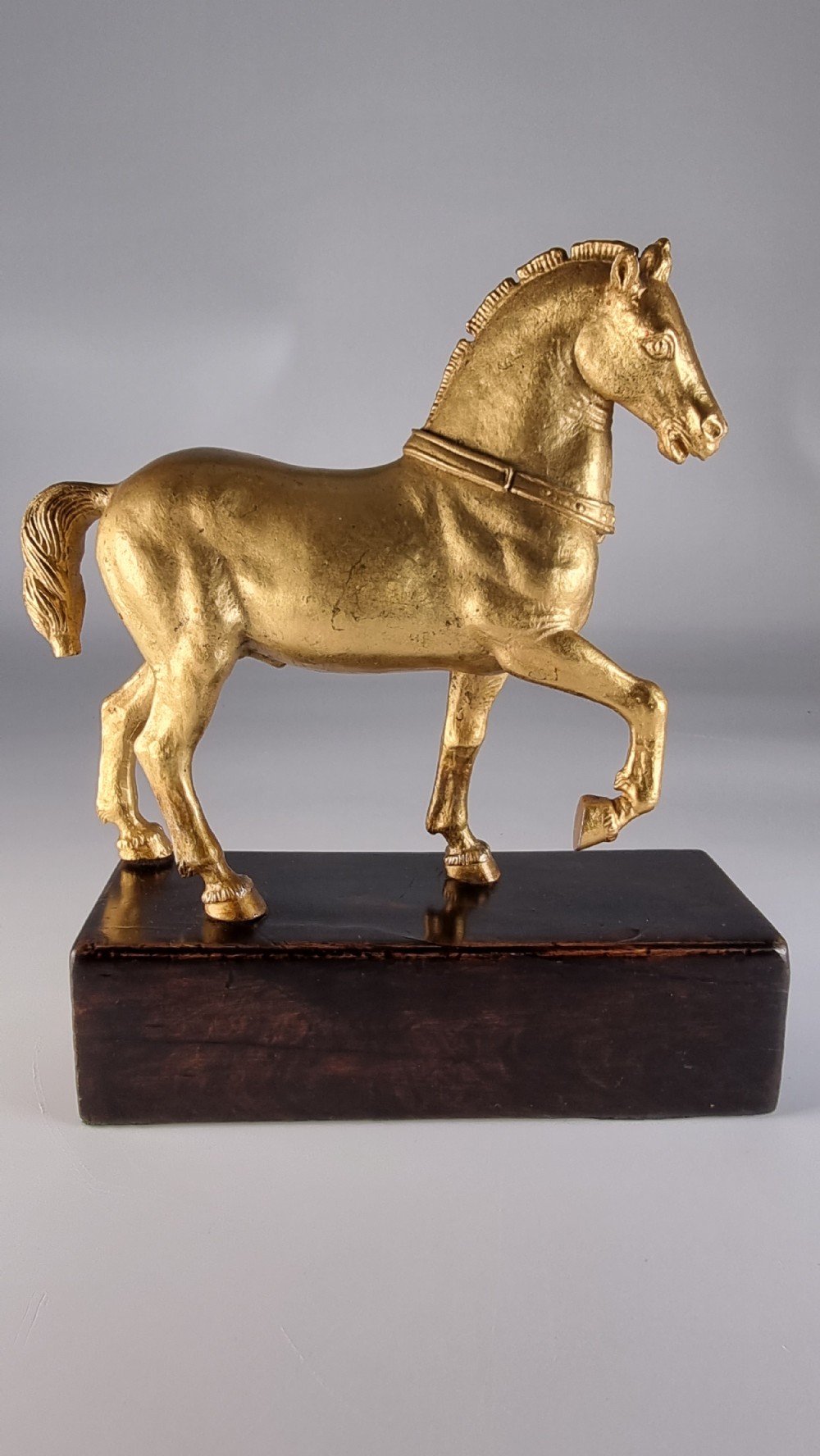 A pair of 19th-century Italian gilt bronze horse sculptures depicted facing each other, mounted on rectangular dark olive wood bases. View XX