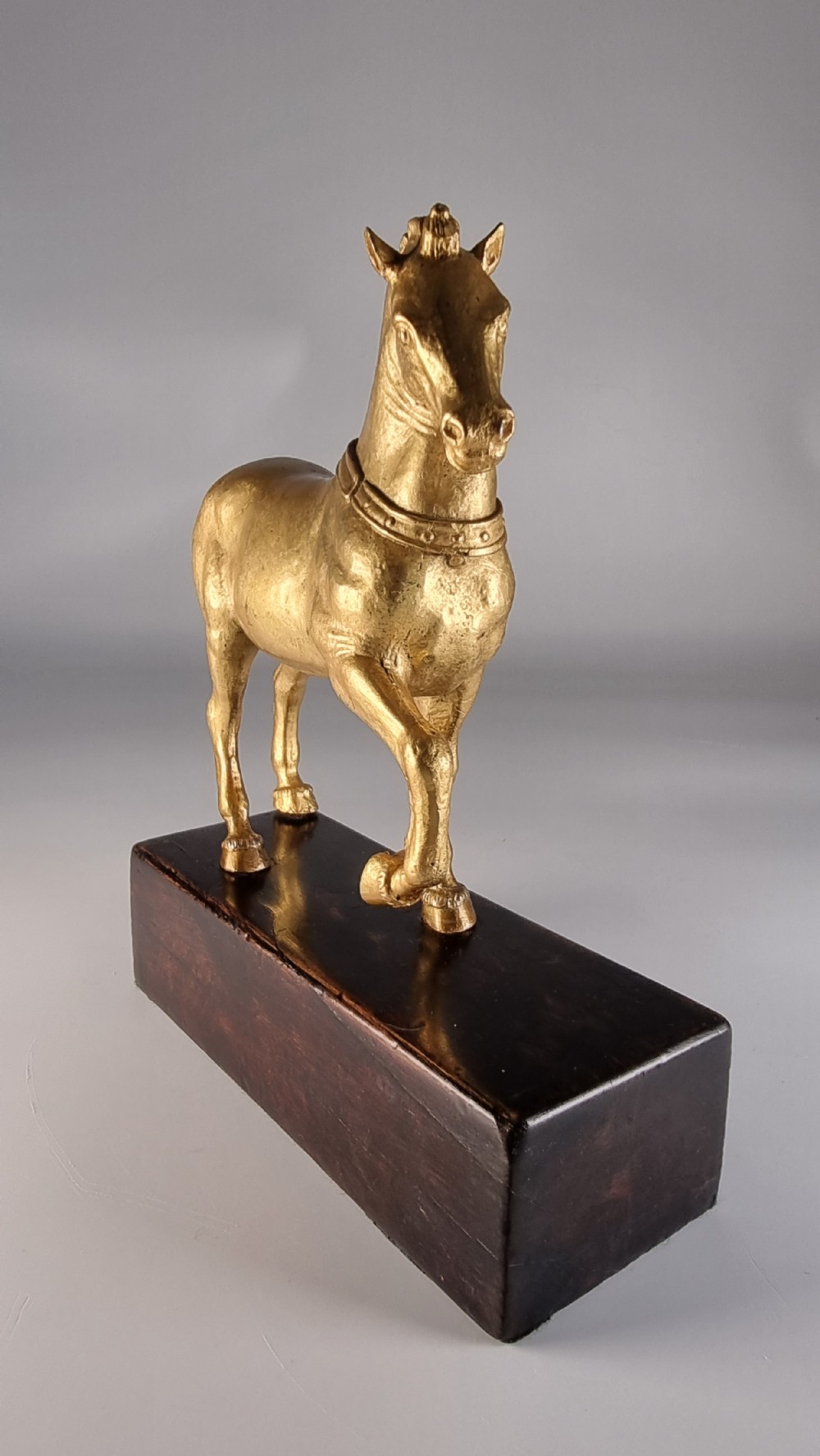 A pair of 19th-century Italian gilt bronze horse sculptures depicted facing each other, mounted on rectangular dark olive wood bases. View XXII