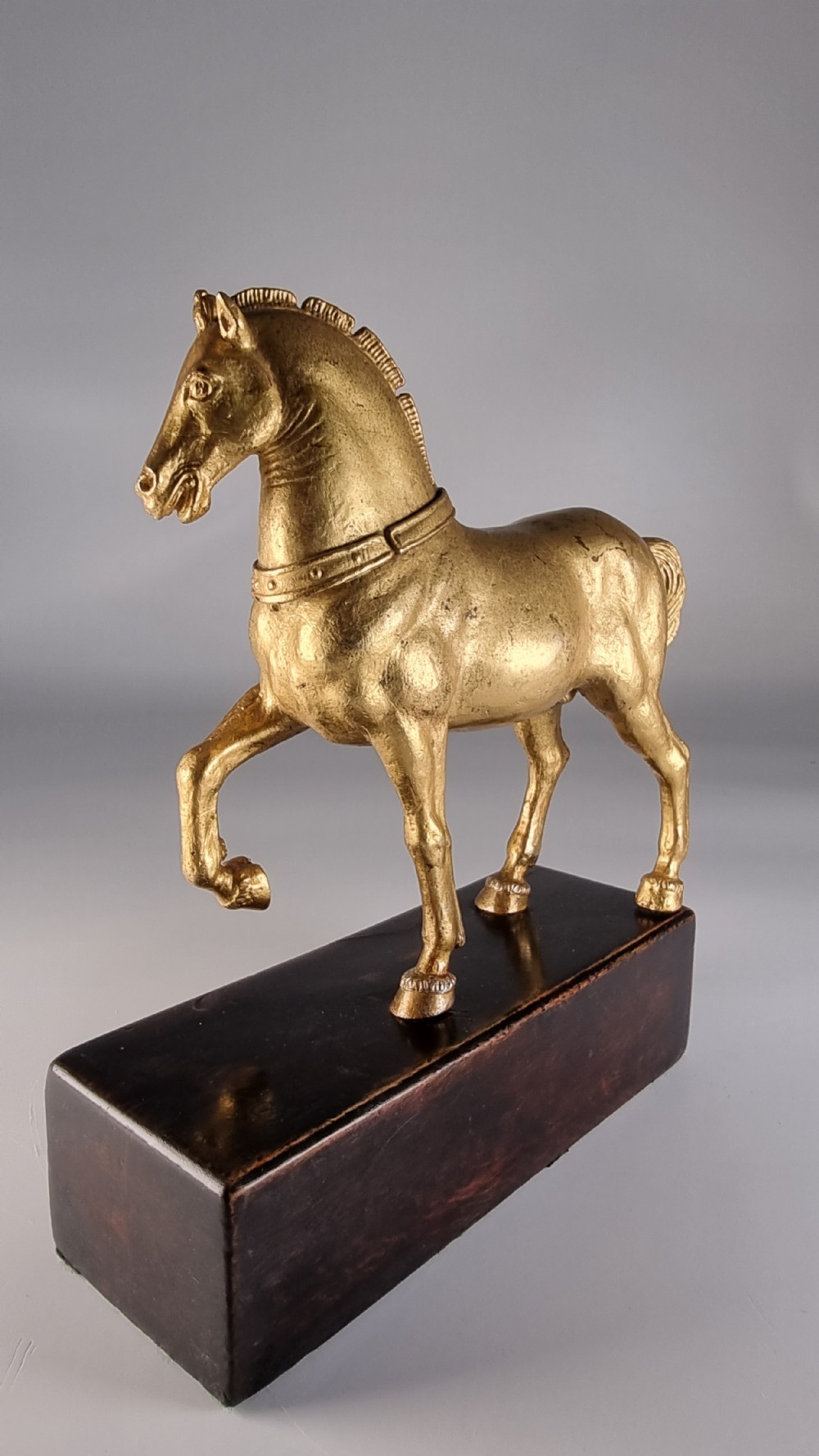 A pair of 19th-century Italian gilt bronze horse sculptures depicted facing each other, mounted on rectangular dark olive wood bases. View XXIII