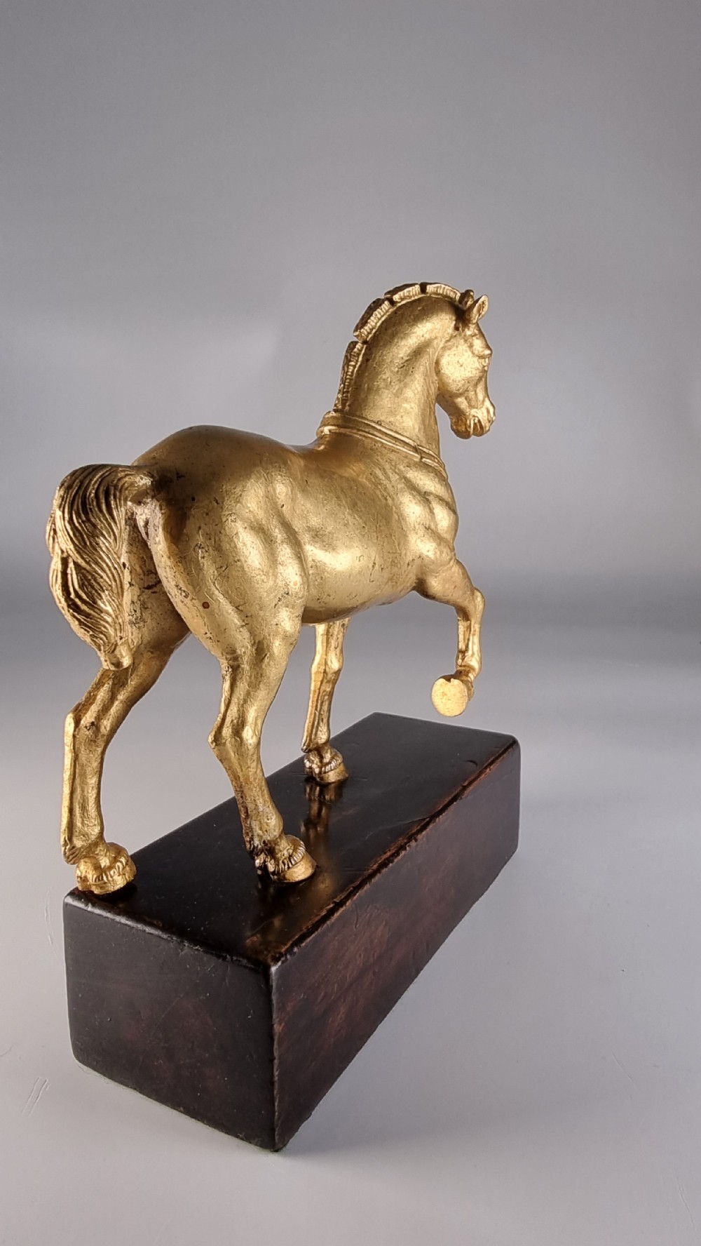 A pair of 19th-century Italian gilt bronze horse sculptures depicted facing each other, mounted on rectangular dark olive wood bases. View XXVII