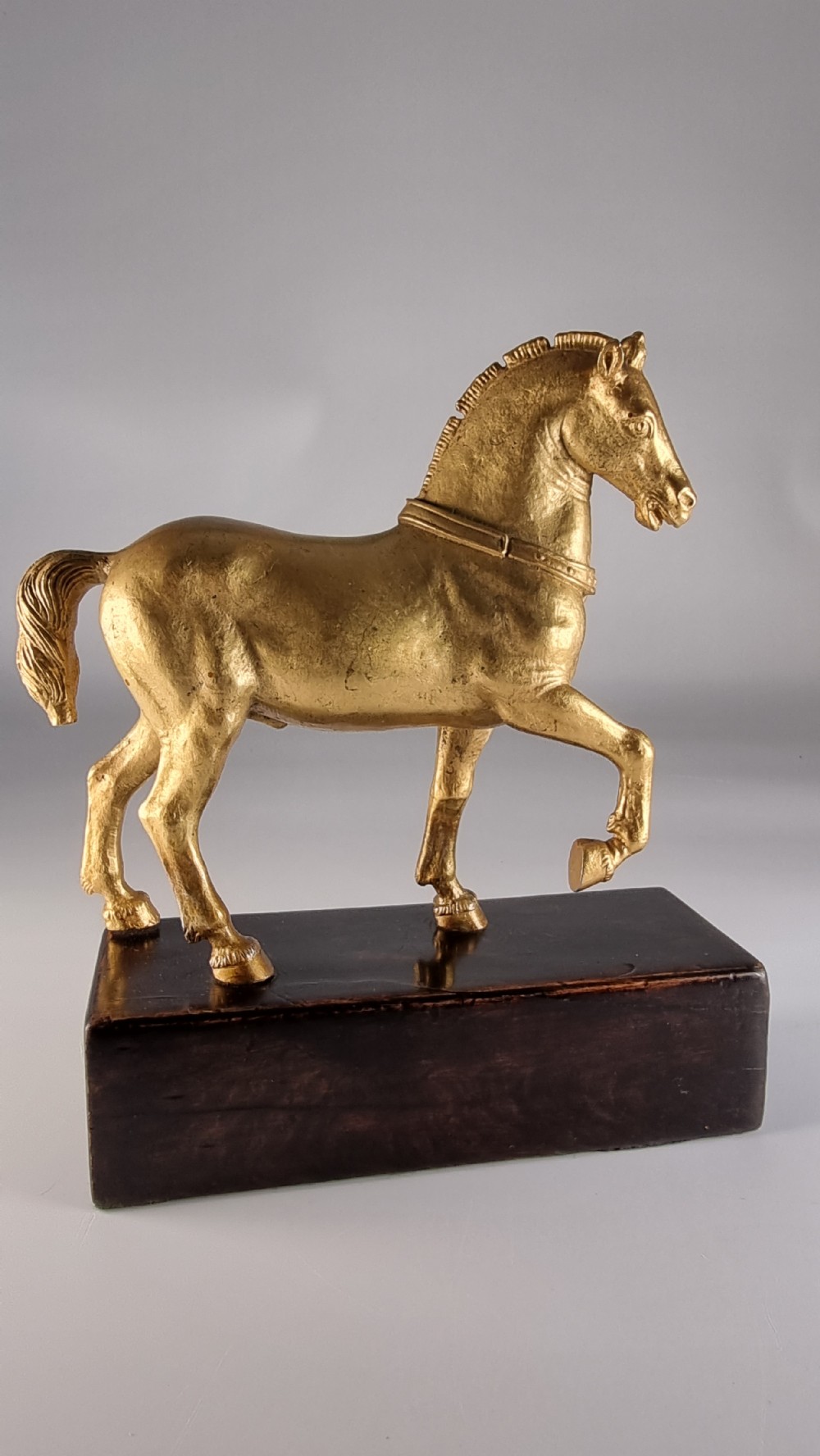 A pair of 19th-century Italian gilt bronze horse sculptures depicted facing each other, mounted on rectangular dark olive wood bases. View XXVIII
