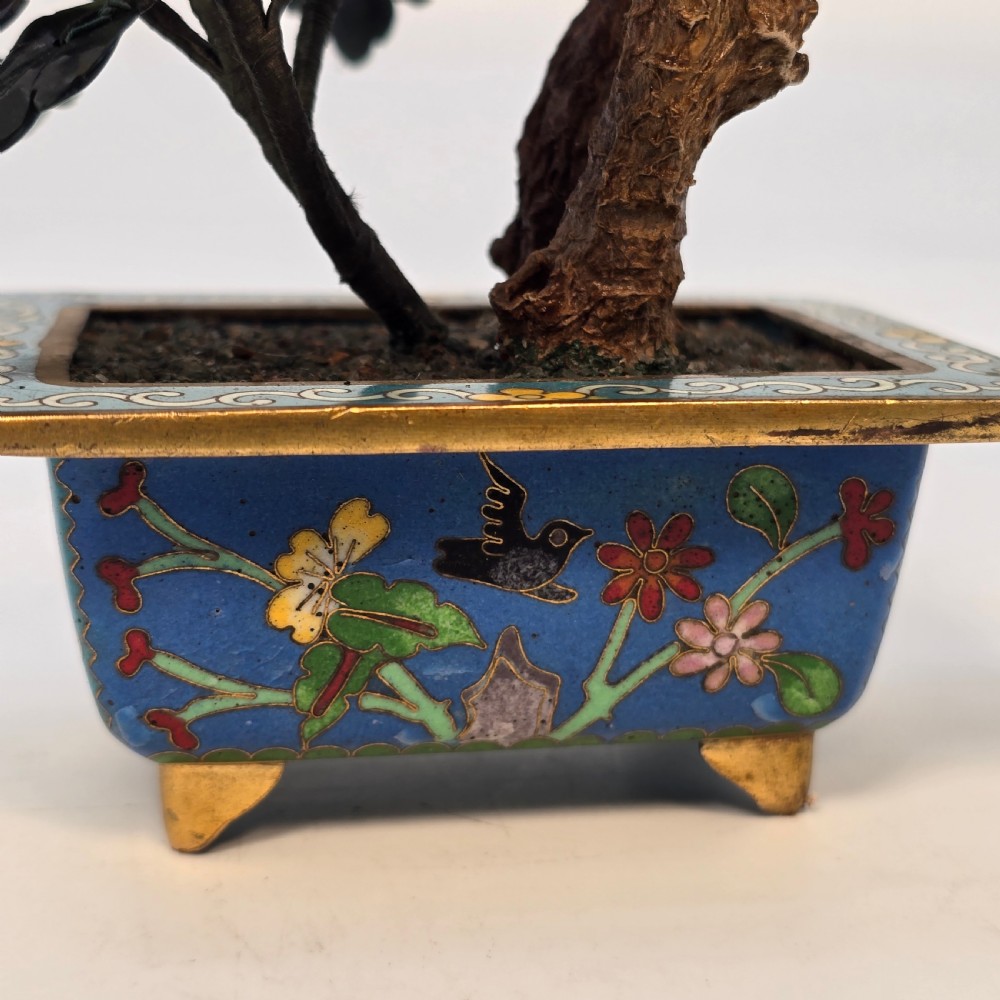A carved hardstone flowering bonsai tree with colourful semi-precious stone petals set inside a rectangular blue cloisonne enamel pot. View XX