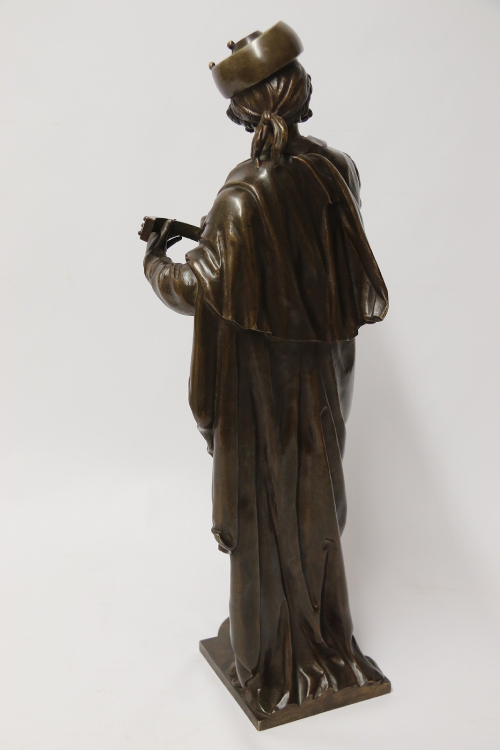 A patinated dark brown bronze sculpture depicting a standing male musician playing a mandolin while wearing a draped coat and headwear. View VI