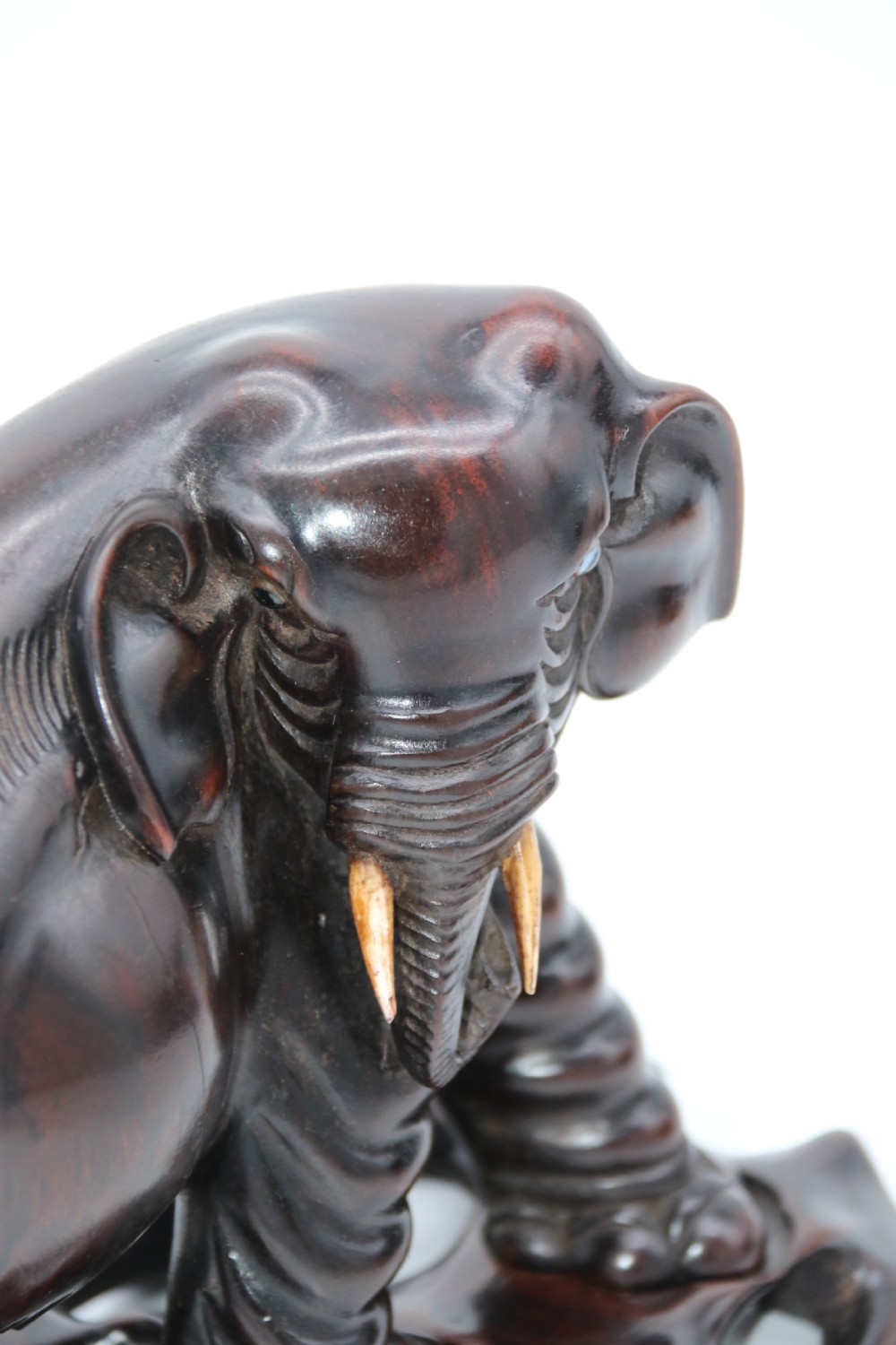 A pair of hand-carved dark hardwood elephant figures standing on pierced wooden bases with exposed tusks. View IX