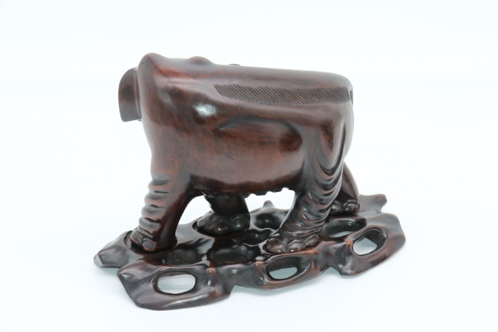 A pair of hand-carved dark hardwood elephant figures standing on pierced wooden bases with exposed tusks. View XIII