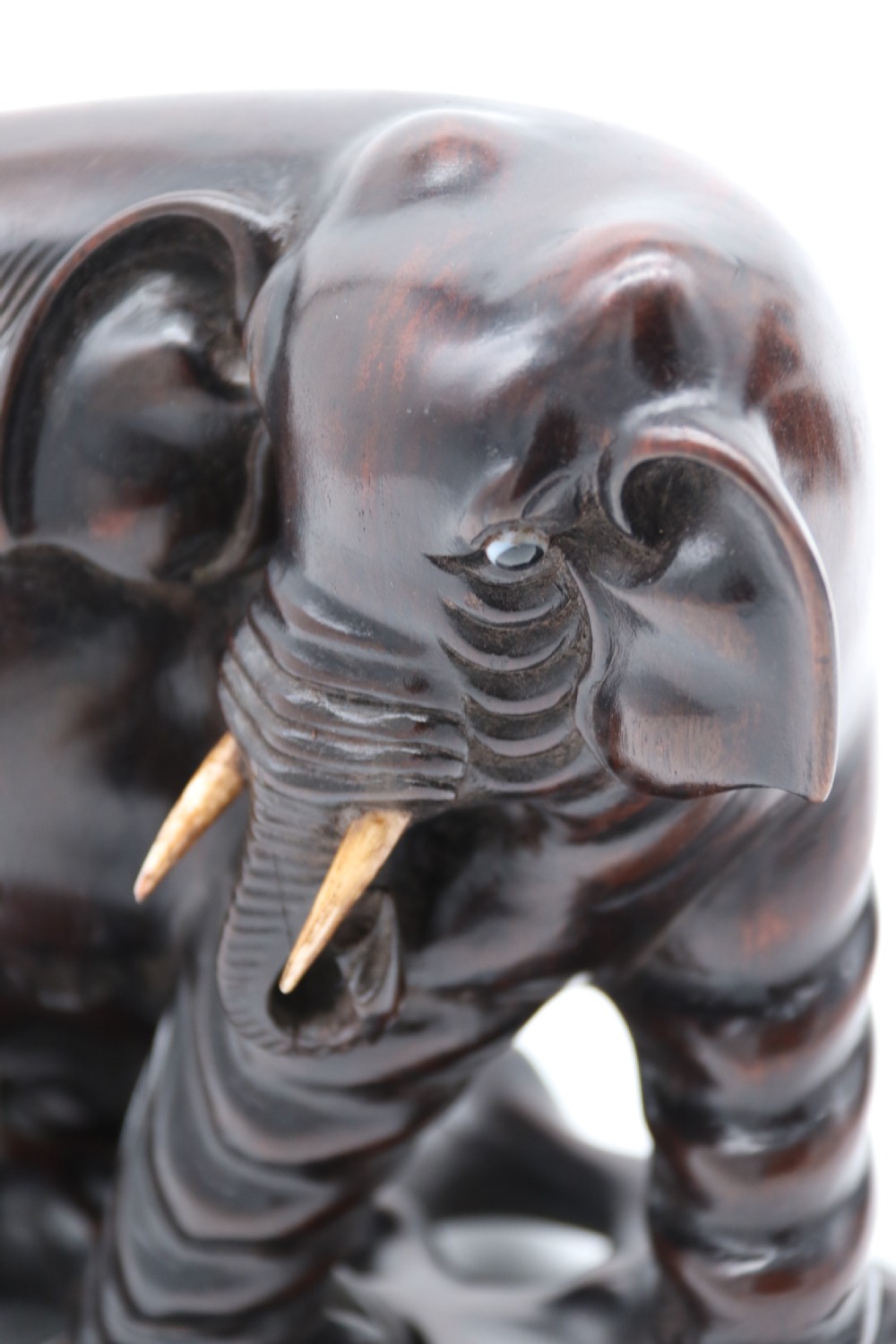 A pair of hand-carved dark hardwood elephant figures standing on pierced wooden bases with exposed tusks. View XIV