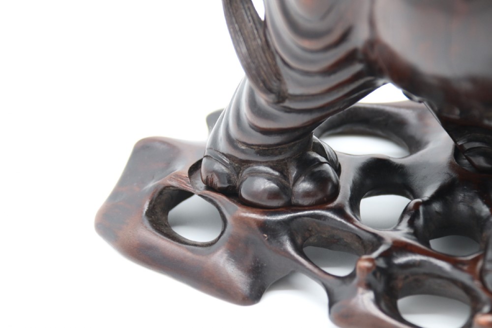 A pair of hand-carved dark hardwood elephant figures standing on pierced wooden bases with exposed tusks. View XVI