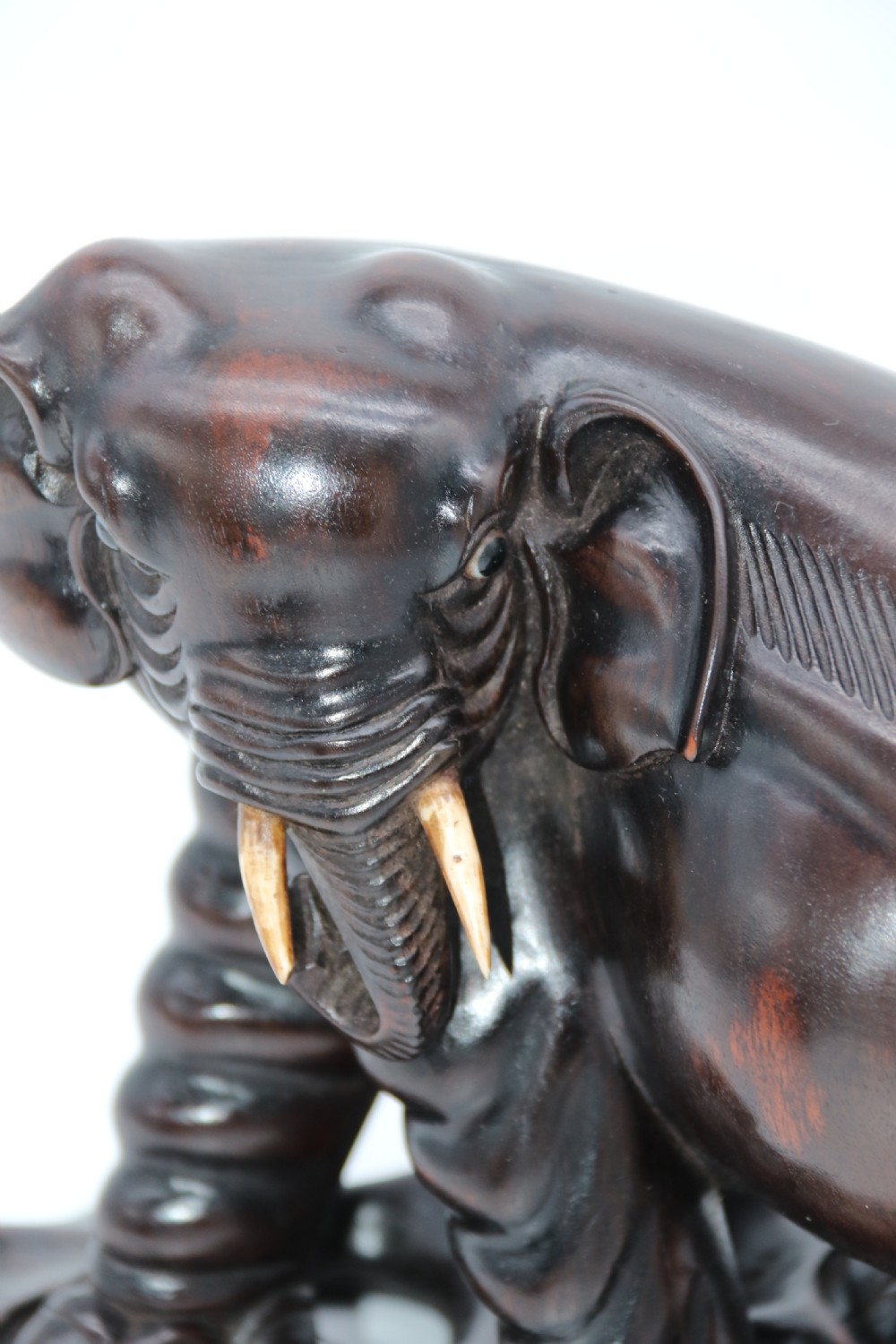 A pair of hand-carved dark hardwood elephant figures standing on pierced wooden bases with exposed tusks. View XXIII