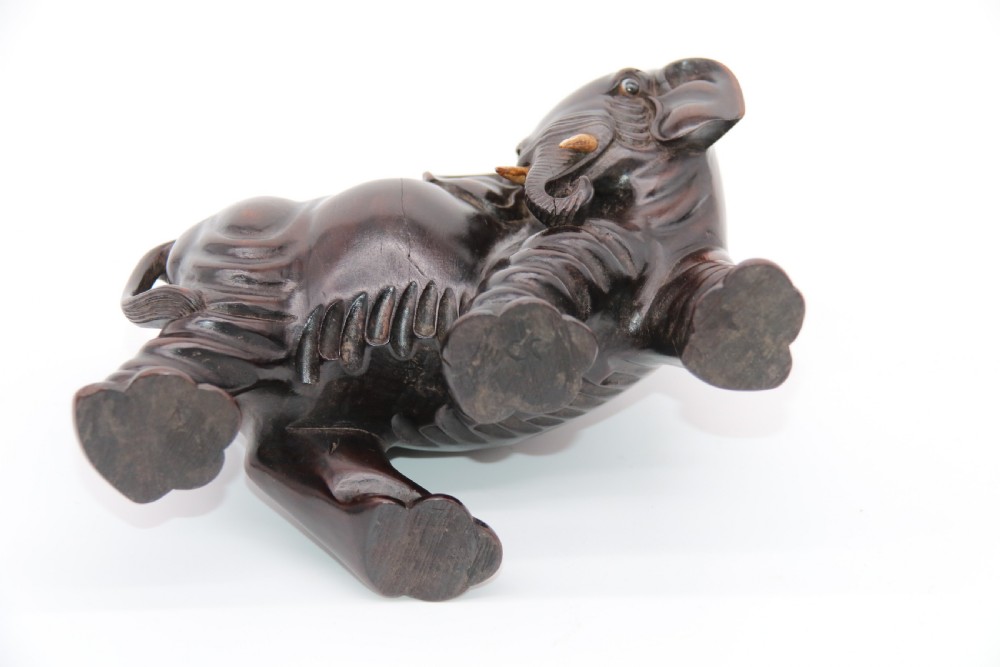 A pair of hand-carved dark hardwood elephant figures standing on pierced wooden bases with exposed tusks. View XXVI