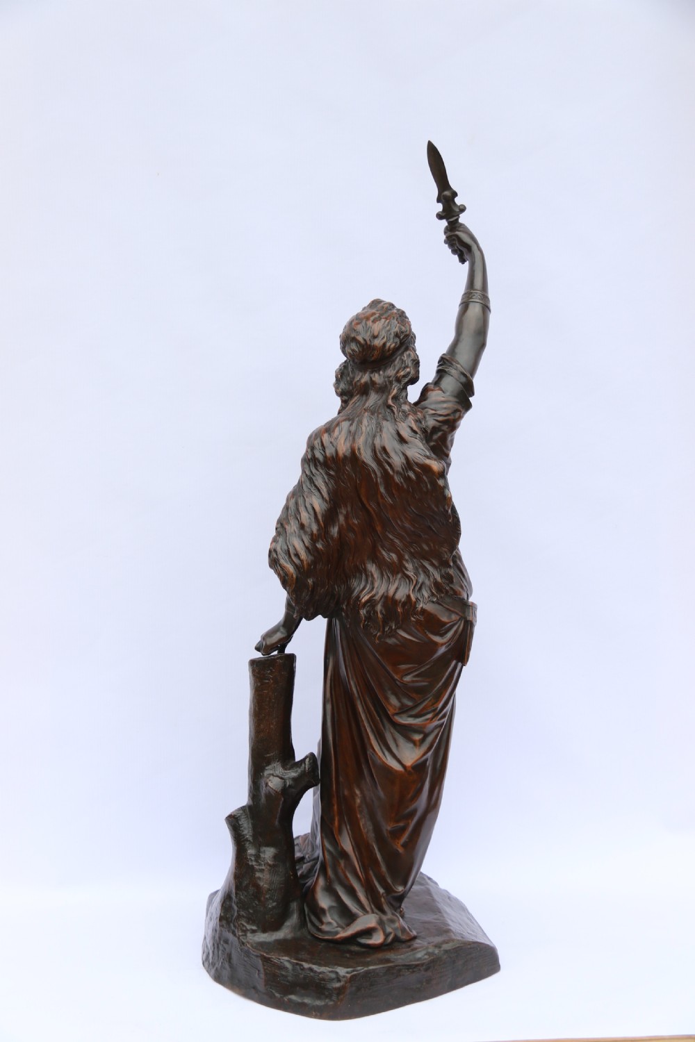 A 19th-century dark patinated bronze sculpture depicting Queen Boadicea in draped robes raising a dagger in her right hand while standing on a rocky base. View V