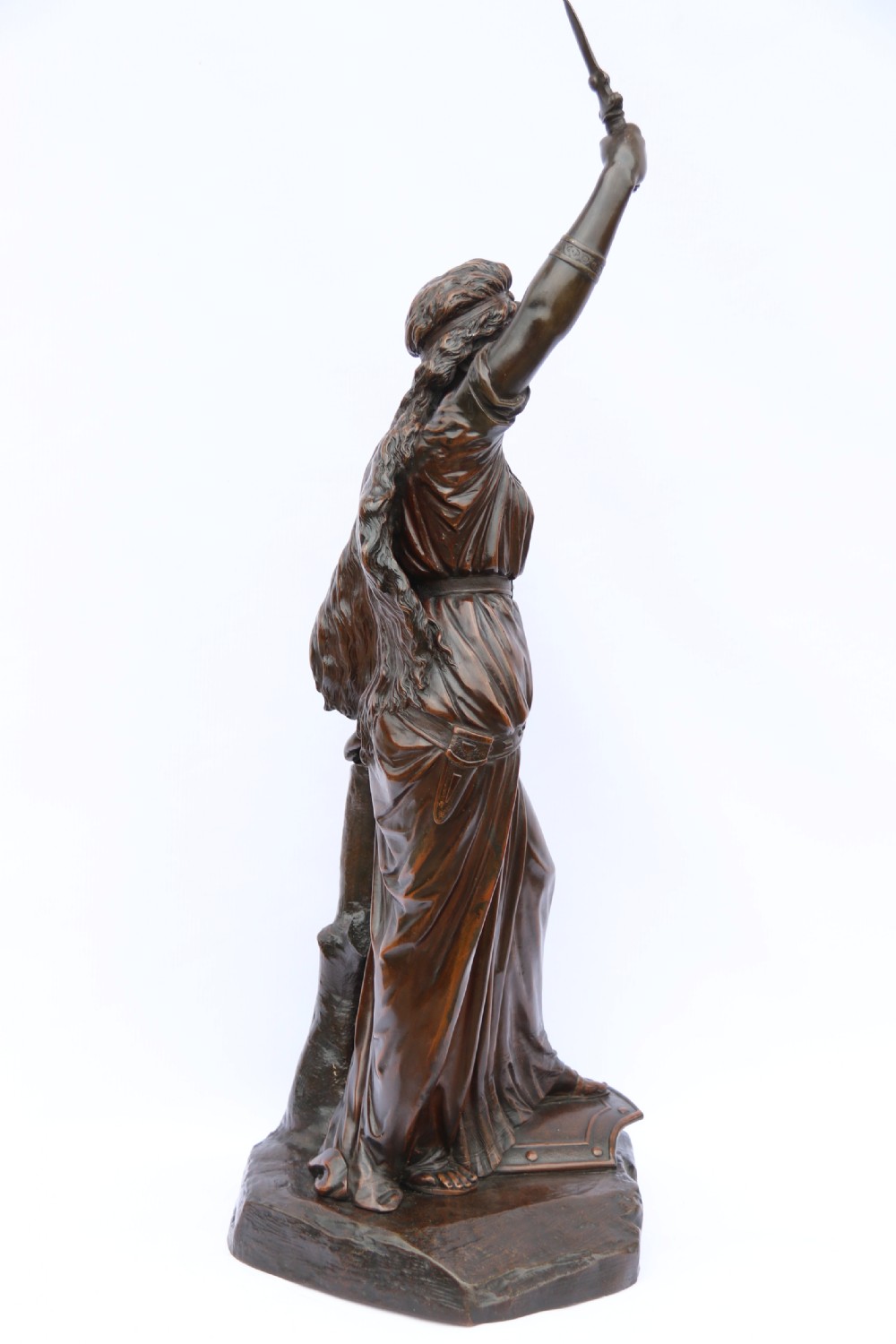 A 19th-century dark patinated bronze sculpture depicting Queen Boadicea in draped robes raising a dagger in her right hand while standing on a rocky base. View VI