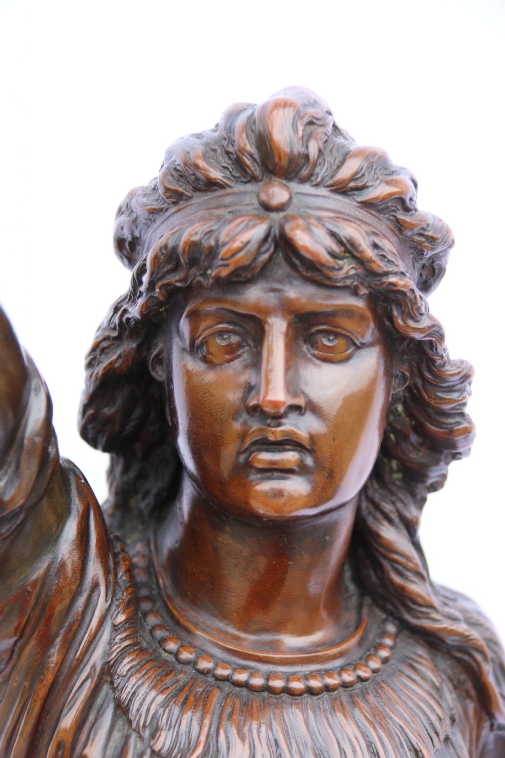 A 19th-century dark patinated bronze sculpture depicting Queen Boadicea in draped robes raising a dagger in her right hand while standing on a rocky base. View X