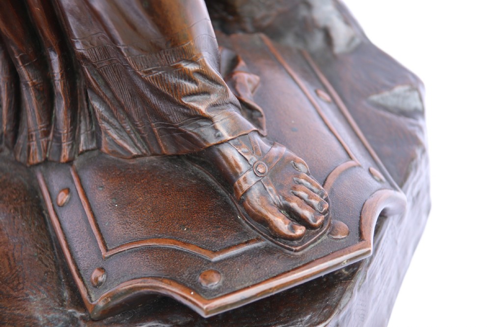 A 19th-century dark patinated bronze sculpture depicting Queen Boadicea in draped robes raising a dagger in her right hand while standing on a rocky base. View XVIII