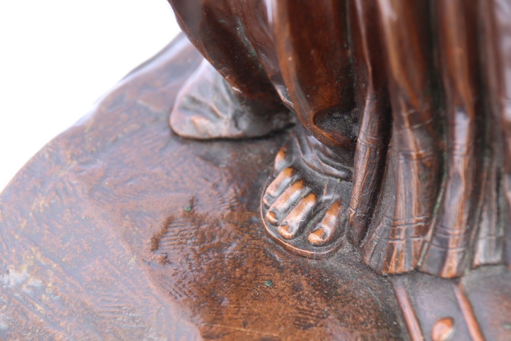 A 19th-century dark patinated bronze sculpture depicting Queen Boadicea in draped robes raising a dagger in her right hand while standing on a rocky base. View XIX