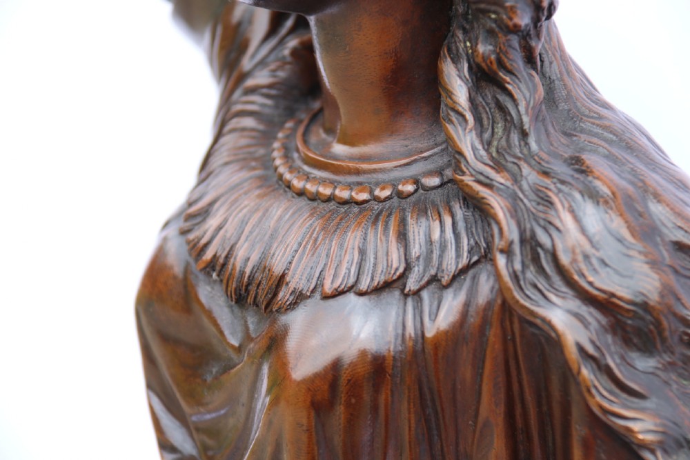 A 19th-century dark patinated bronze sculpture depicting Queen Boadicea in draped robes raising a dagger in her right hand while standing on a rocky base. View XX