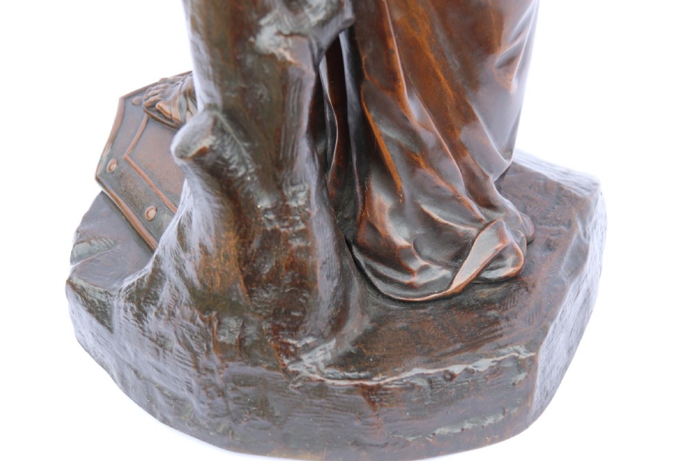 A 19th-century dark patinated bronze sculpture depicting Queen Boadicea in draped robes raising a dagger in her right hand while standing on a rocky base. View XXIV