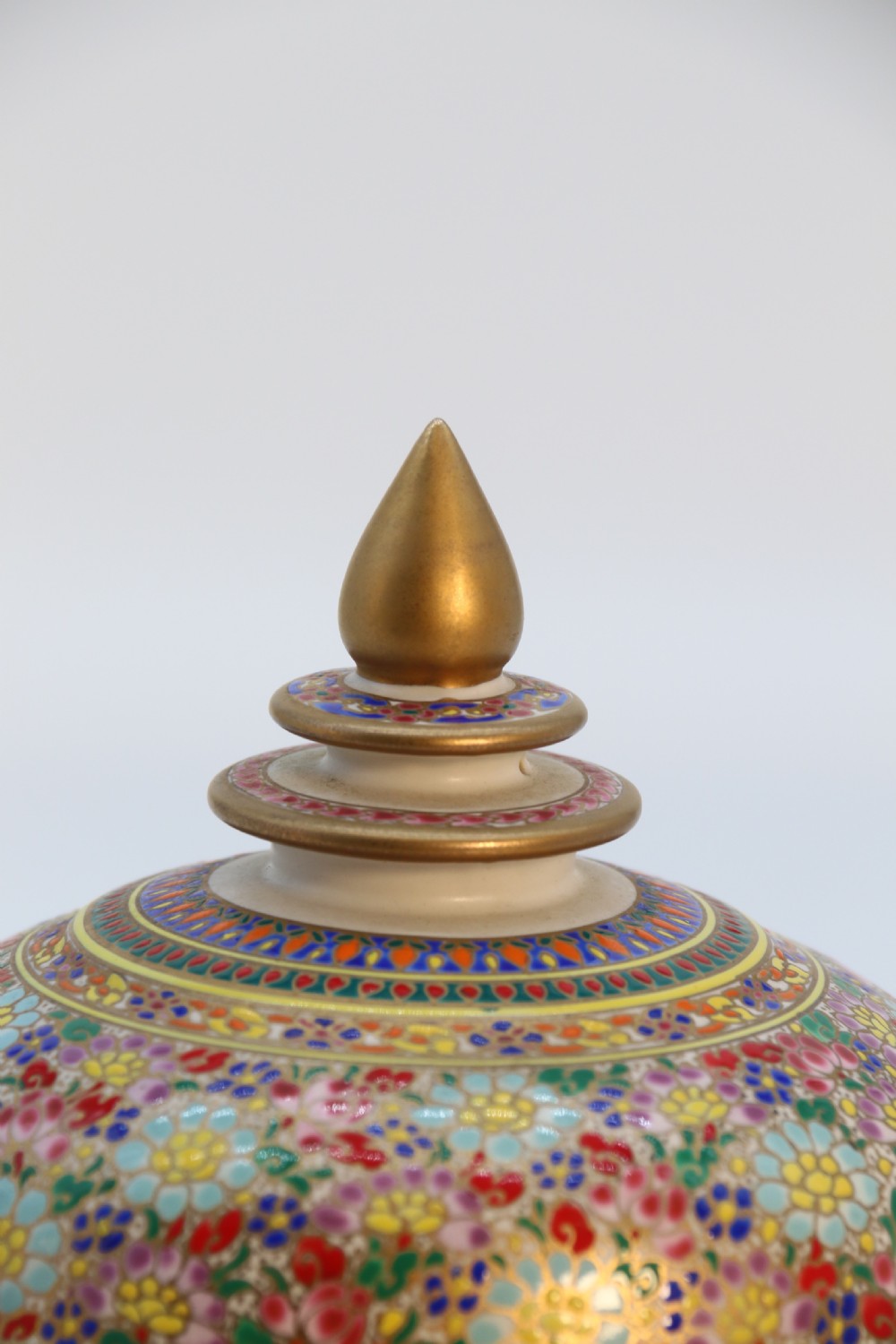 A polychrome enamelled ceramic jar with a fitted stepped lid featuring intricate floral motifs and a gilded conical finial. View XV
