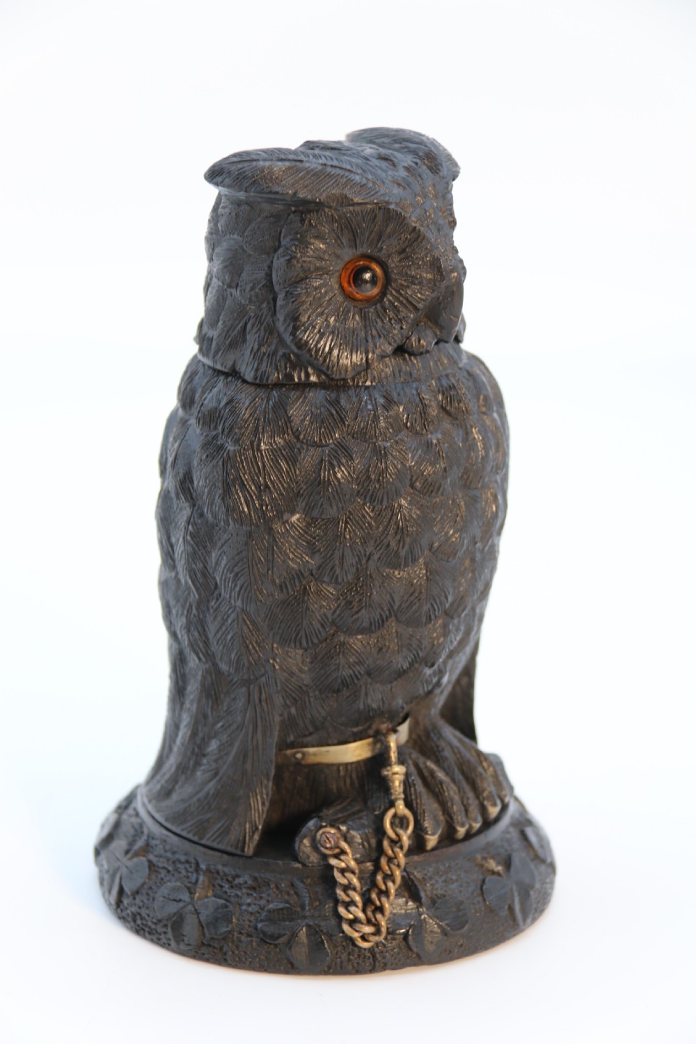 A hand-carved dark oak inkstand crafted in the likeness of an owl with glass eyes and a brass tether, resting on a carved base with shamrock details. View II