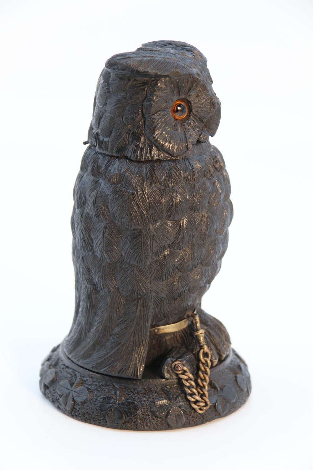 A hand-carved dark oak inkstand crafted in the likeness of an owl with glass eyes and a brass tether, resting on a carved base with shamrock details. View III