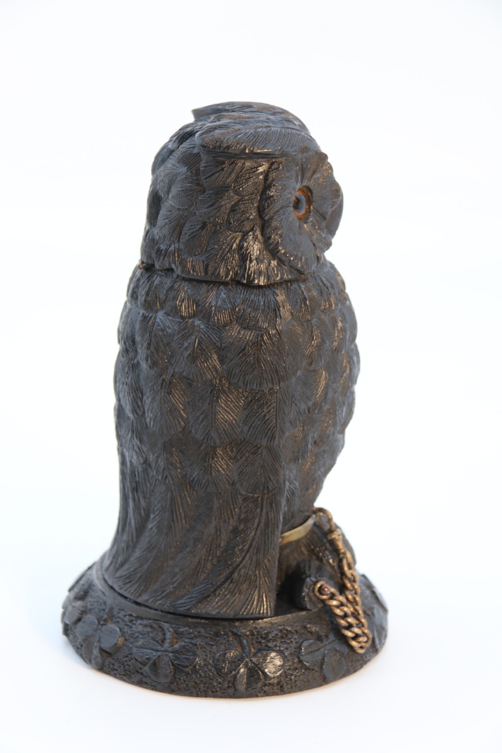 A hand-carved dark oak inkstand crafted in the likeness of an owl with glass eyes and a brass tether, resting on a carved base with shamrock details. View IV