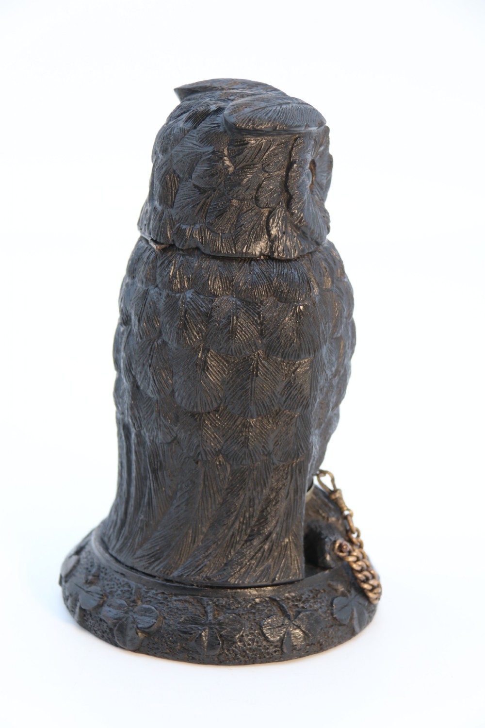 A hand-carved dark oak inkstand crafted in the likeness of an owl with glass eyes and a brass tether, resting on a carved base with shamrock details. View V