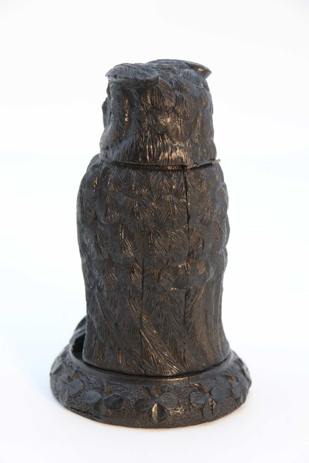 A hand-carved dark oak inkstand crafted in the likeness of an owl with glass eyes and a brass tether, resting on a carved base with shamrock details. View VII