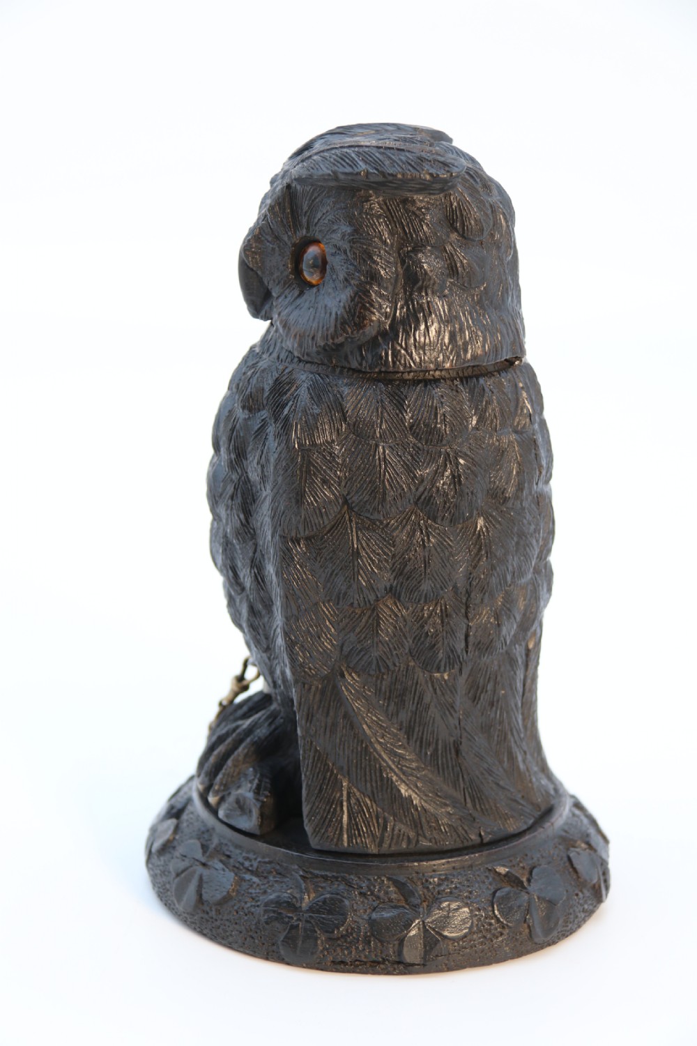 A hand-carved dark oak inkstand crafted in the likeness of an owl with glass eyes and a brass tether, resting on a carved base with shamrock details. View VIII