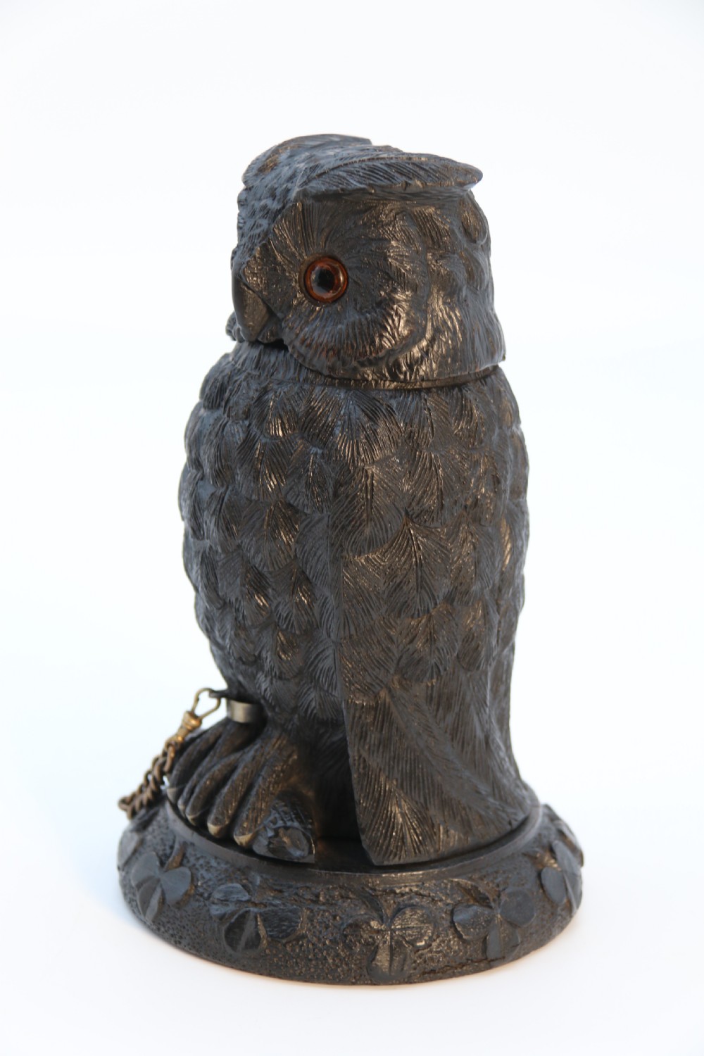 A hand-carved dark oak inkstand crafted in the likeness of an owl with glass eyes and a brass tether, resting on a carved base with shamrock details. View IX