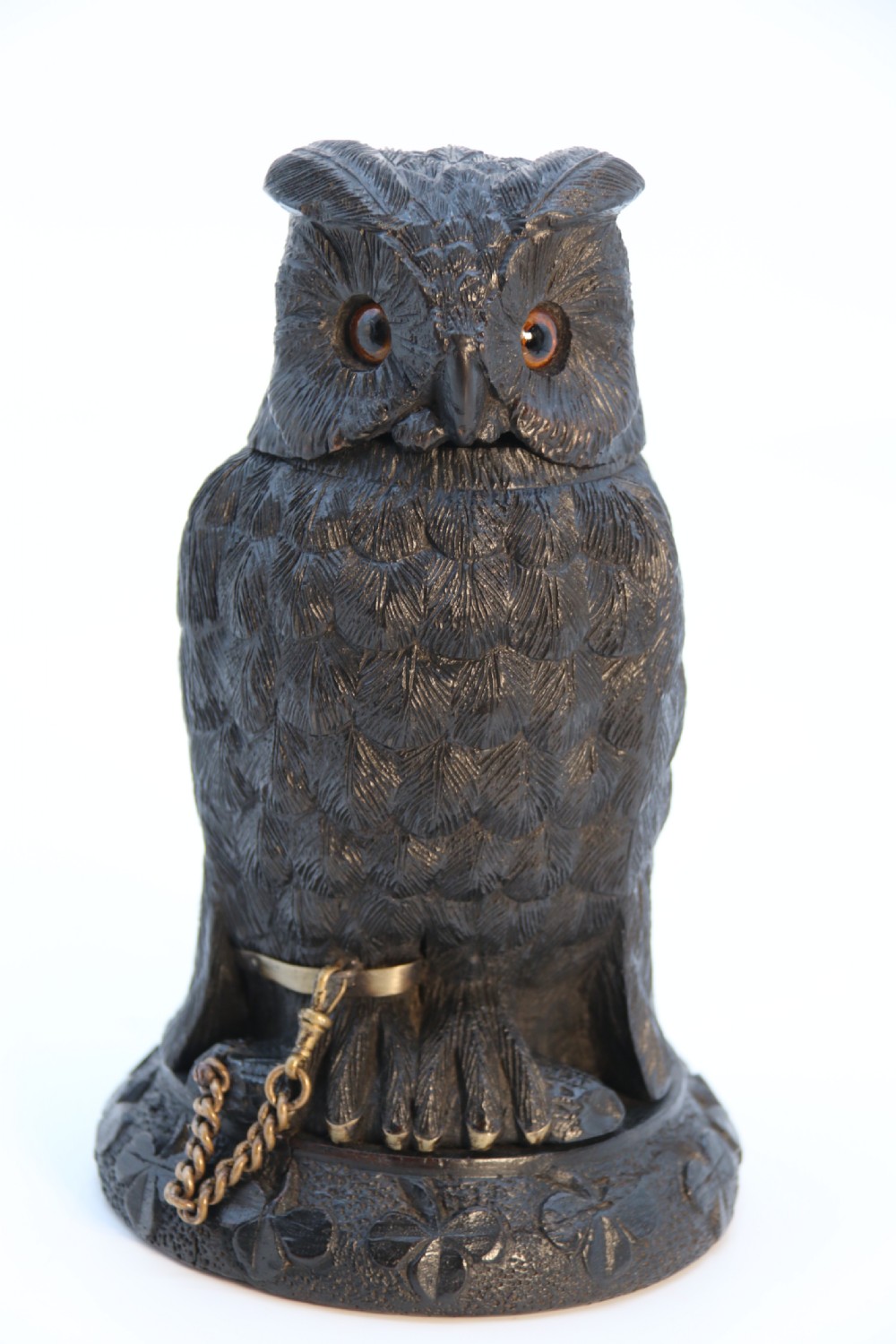A hand-carved dark oak inkstand crafted in the likeness of an owl with glass eyes and a brass tether, resting on a carved base with shamrock details. View XI