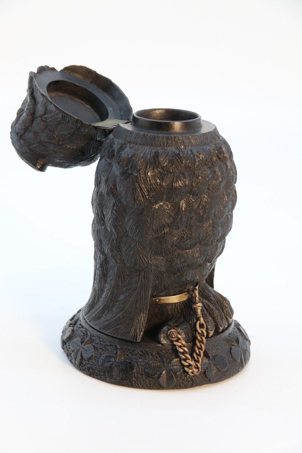 A hand-carved dark oak inkstand crafted in the likeness of an owl with glass eyes and a brass tether, resting on a carved base with shamrock details. View XII