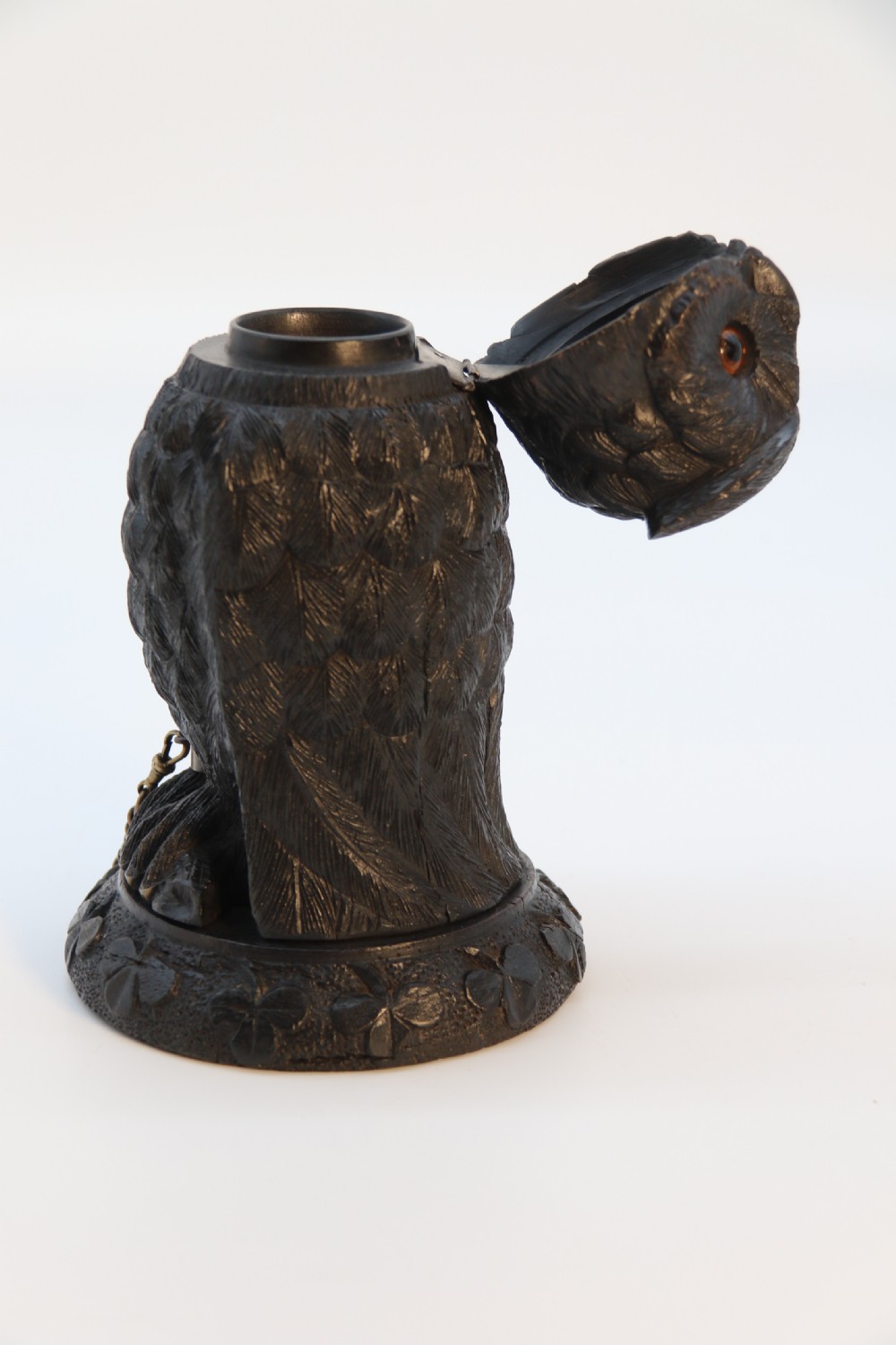 A hand-carved dark oak inkstand crafted in the likeness of an owl with glass eyes and a brass tether, resting on a carved base with shamrock details. View XIII