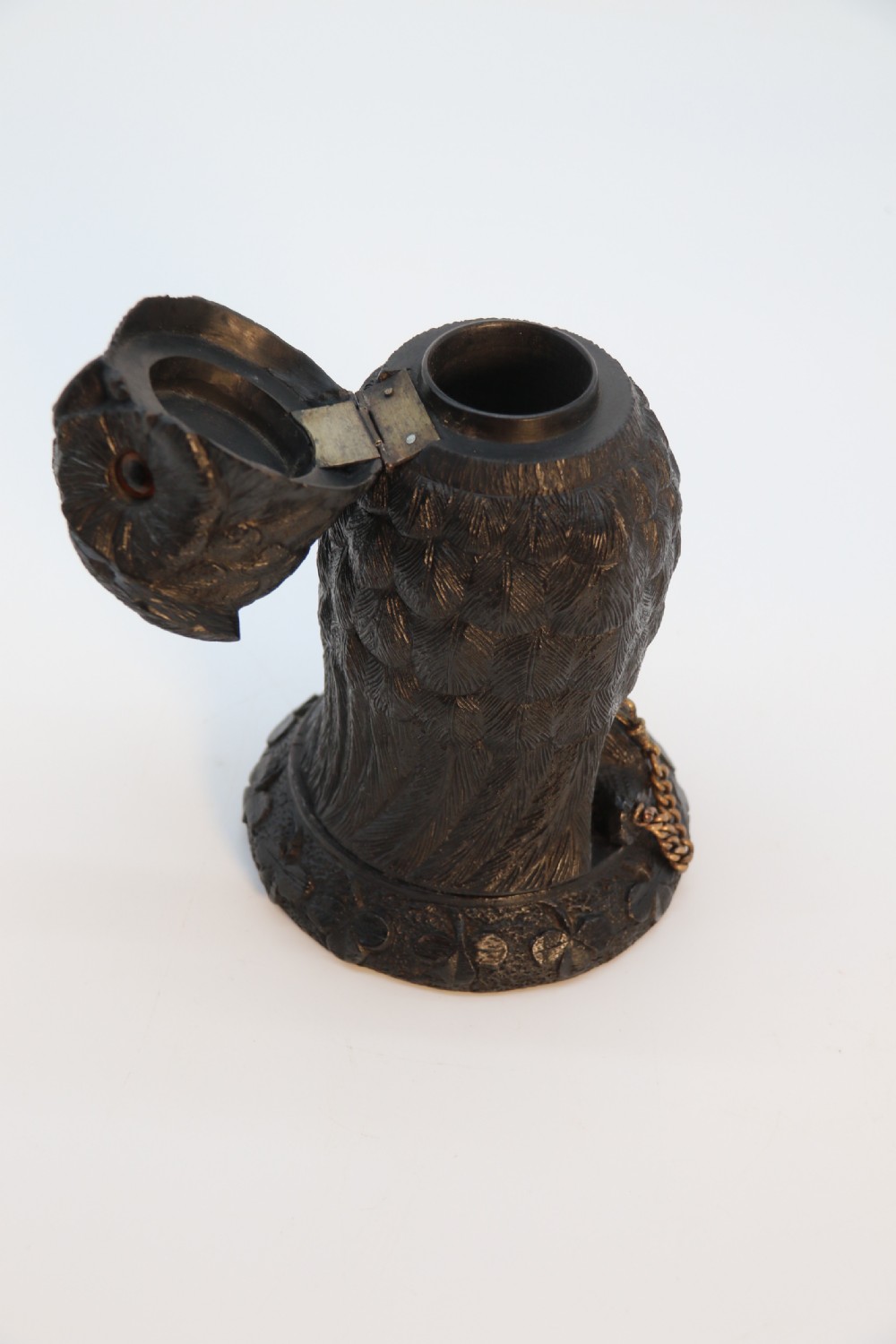 A hand-carved dark oak inkstand crafted in the likeness of an owl with glass eyes and a brass tether, resting on a carved base with shamrock details. View XV