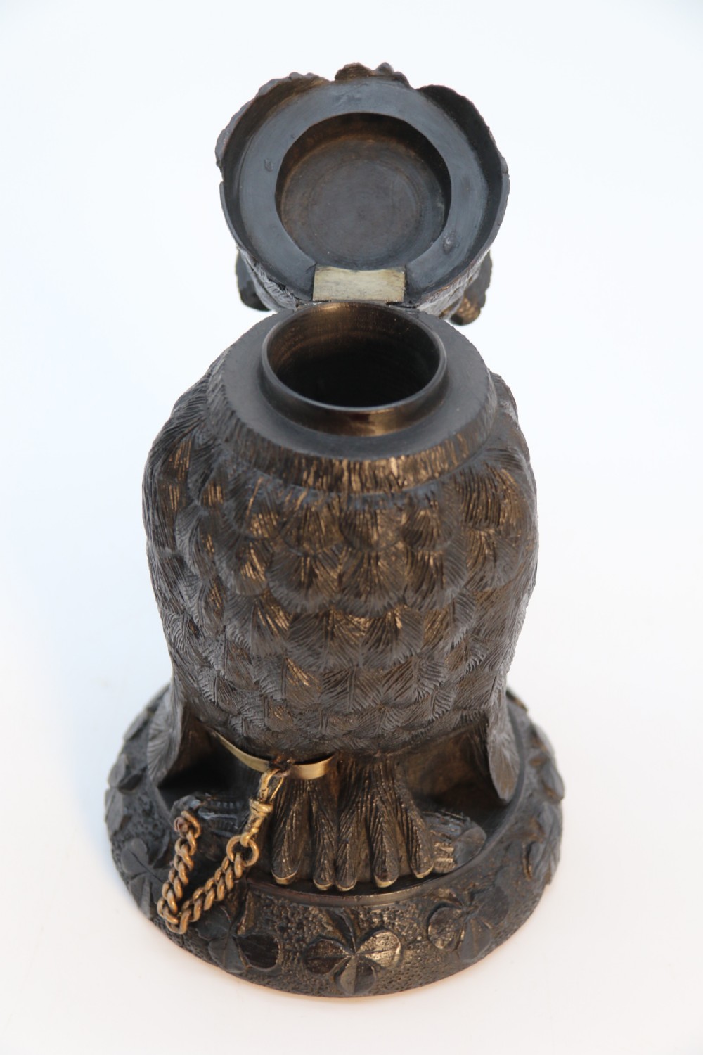 A hand-carved dark oak inkstand crafted in the likeness of an owl with glass eyes and a brass tether, resting on a carved base with shamrock details. View XVI