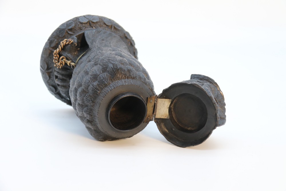 A hand-carved dark oak inkstand crafted in the likeness of an owl with glass eyes and a brass tether, resting on a carved base with shamrock details. View XVIII