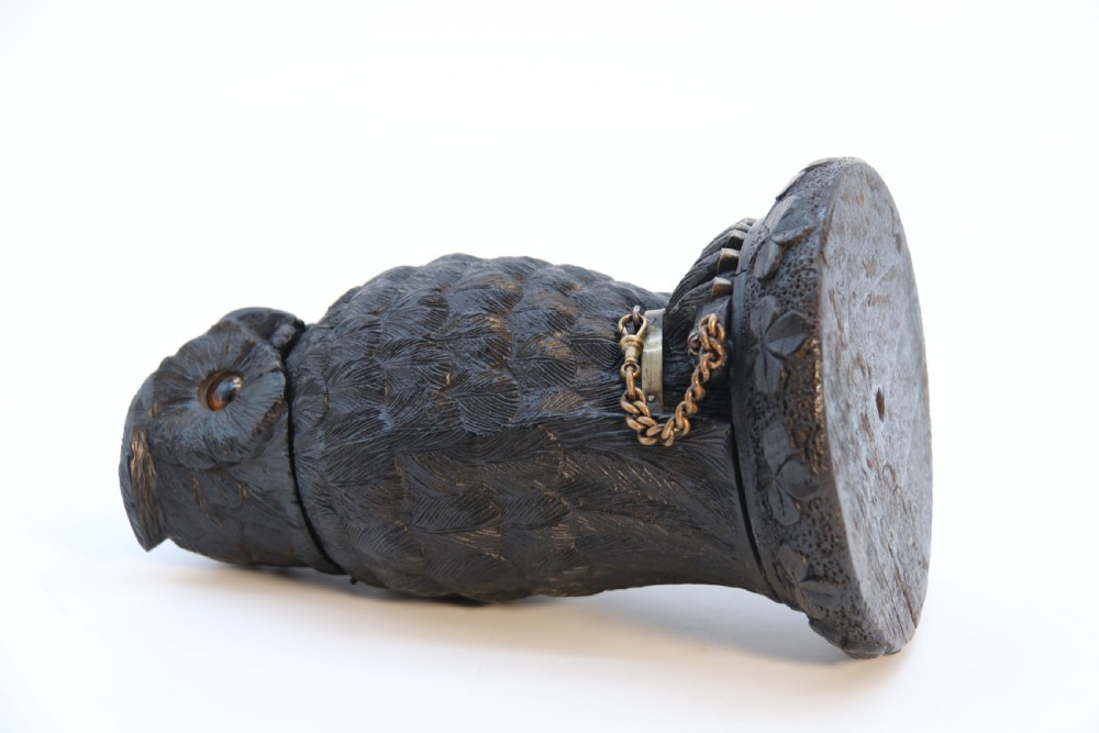 A hand-carved dark oak inkstand crafted in the likeness of an owl with glass eyes and a brass tether, resting on a carved base with shamrock details. View XX