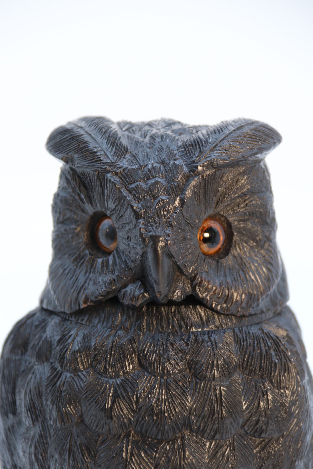 A hand-carved dark oak inkstand crafted in the likeness of an owl with glass eyes and a brass tether, resting on a carved base with shamrock details. View XXI