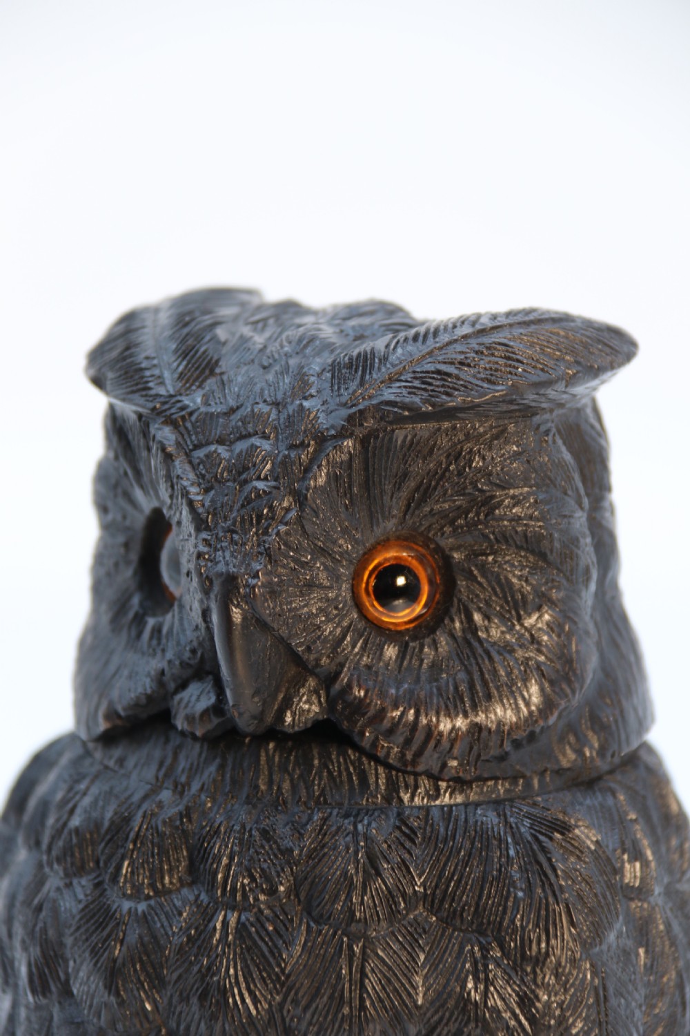 A hand-carved dark oak inkstand crafted in the likeness of an owl with glass eyes and a brass tether, resting on a carved base with shamrock details. View XXII