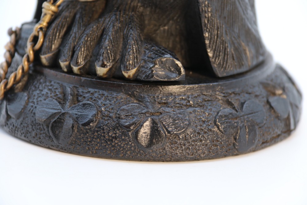 A hand-carved dark oak inkstand crafted in the likeness of an owl with glass eyes and a brass tether, resting on a carved base with shamrock details. View XXIV