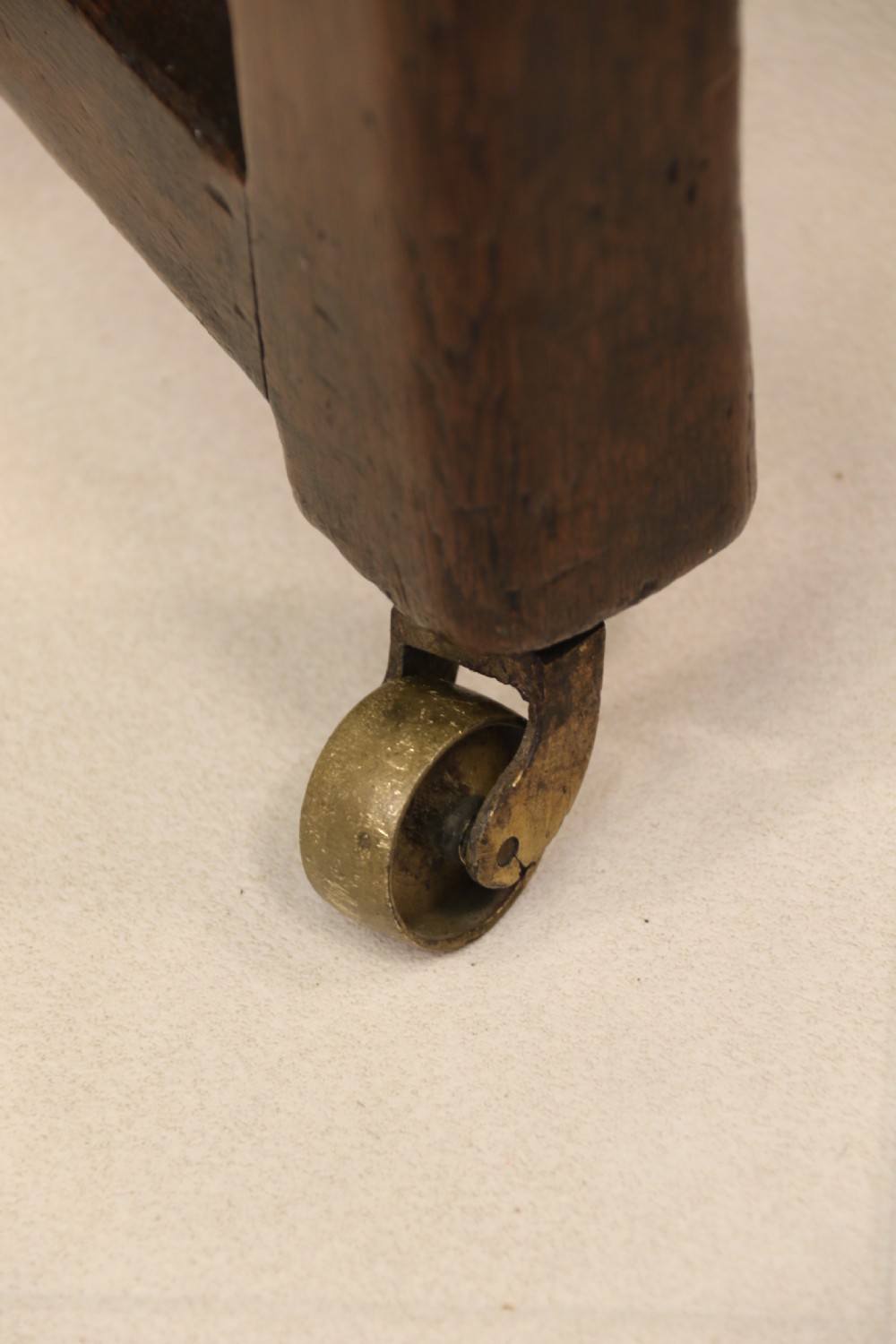 A George III chestnut brown leather wingback armchair featuring deep button tufting, brass stud detail, square wooden legs with stretchers, and brass castors. View XIII