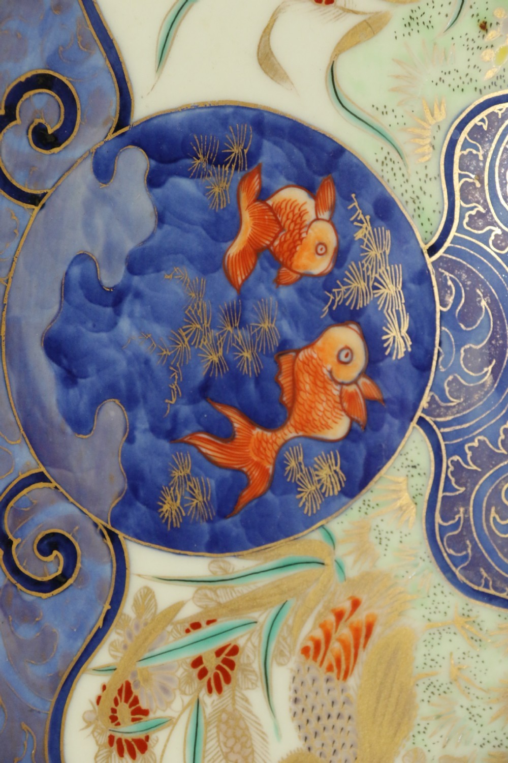 A circular hand-painted Japanese Imari porcelain charger featuring cobalt blue, iron red, and gilt decorative panels depicting birds, goldfish, and botanical motifs. View III