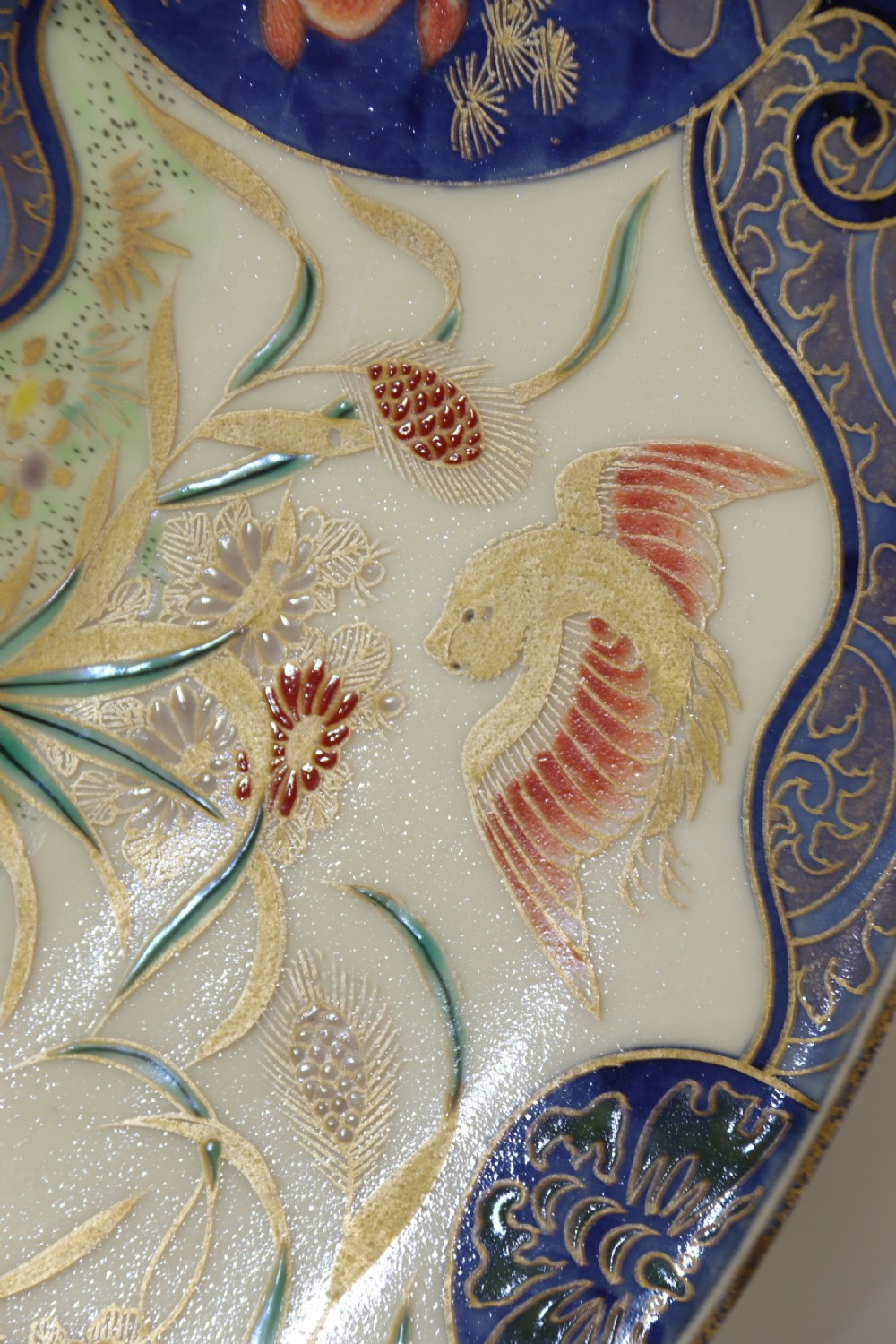 A circular hand-painted Japanese Imari porcelain charger featuring cobalt blue, iron red, and gilt decorative panels depicting birds, goldfish, and botanical motifs. View IV