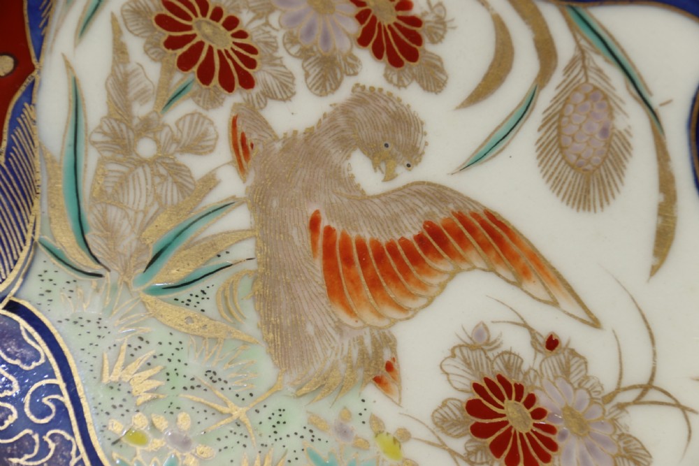 A circular hand-painted Japanese Imari porcelain charger featuring cobalt blue, iron red, and gilt decorative panels depicting birds, goldfish, and botanical motifs. View VIII