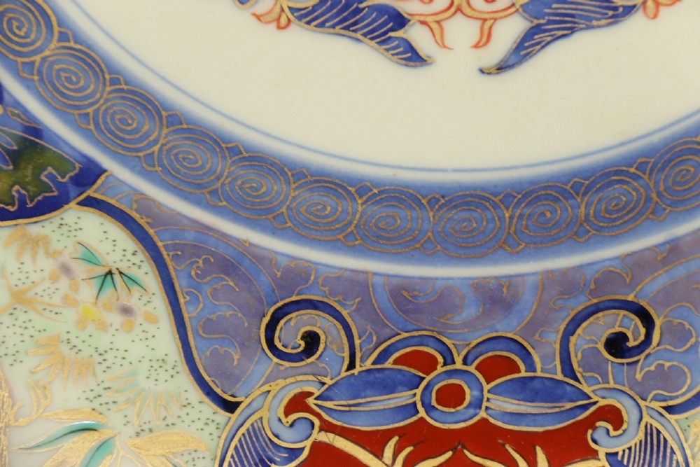 A circular hand-painted Japanese Imari porcelain charger featuring cobalt blue, iron red, and gilt decorative panels depicting birds, goldfish, and botanical motifs. View IX