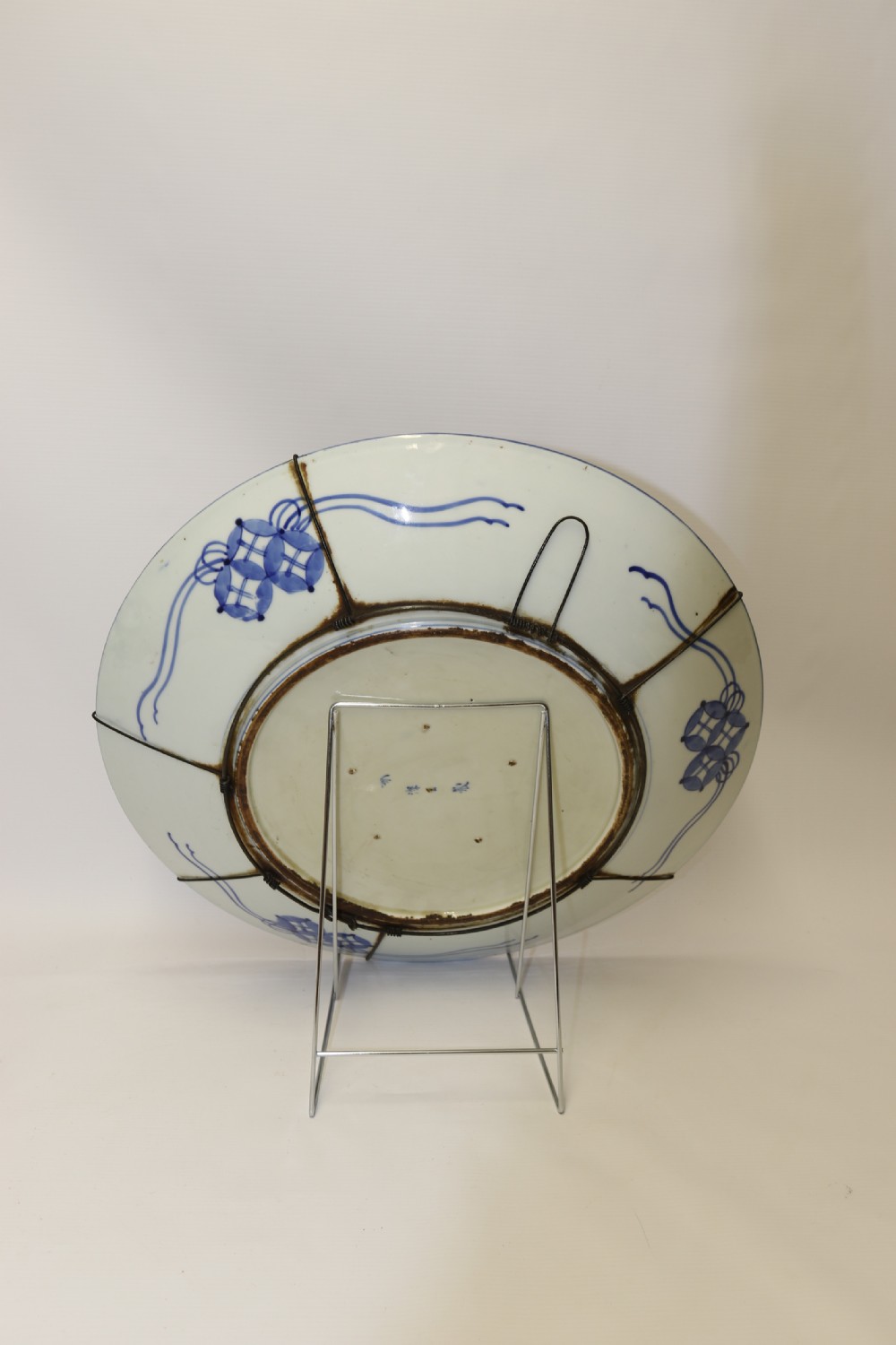 A circular hand-painted Japanese Imari porcelain charger featuring cobalt blue, iron red, and gilt decorative panels depicting birds, goldfish, and botanical motifs. View X